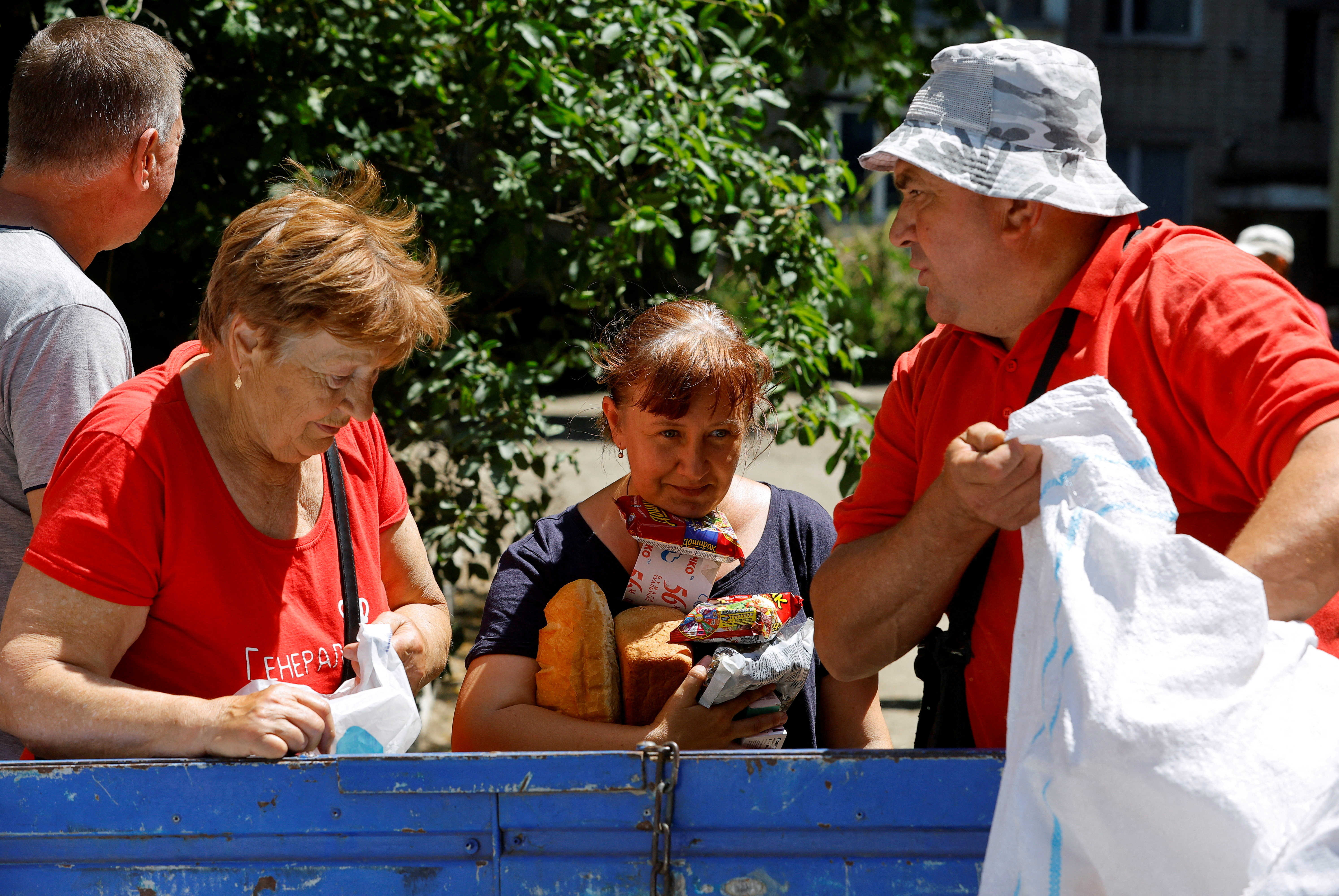 Local residents receive water and food aid after floodwaters receded following the collapse of the Nova Kakhovka dam in the course of Russia-Ukraine conflict, in the town of Hola Prystan in the Kherson region, Russian-controlled Ukraine, June 17, 2023. 