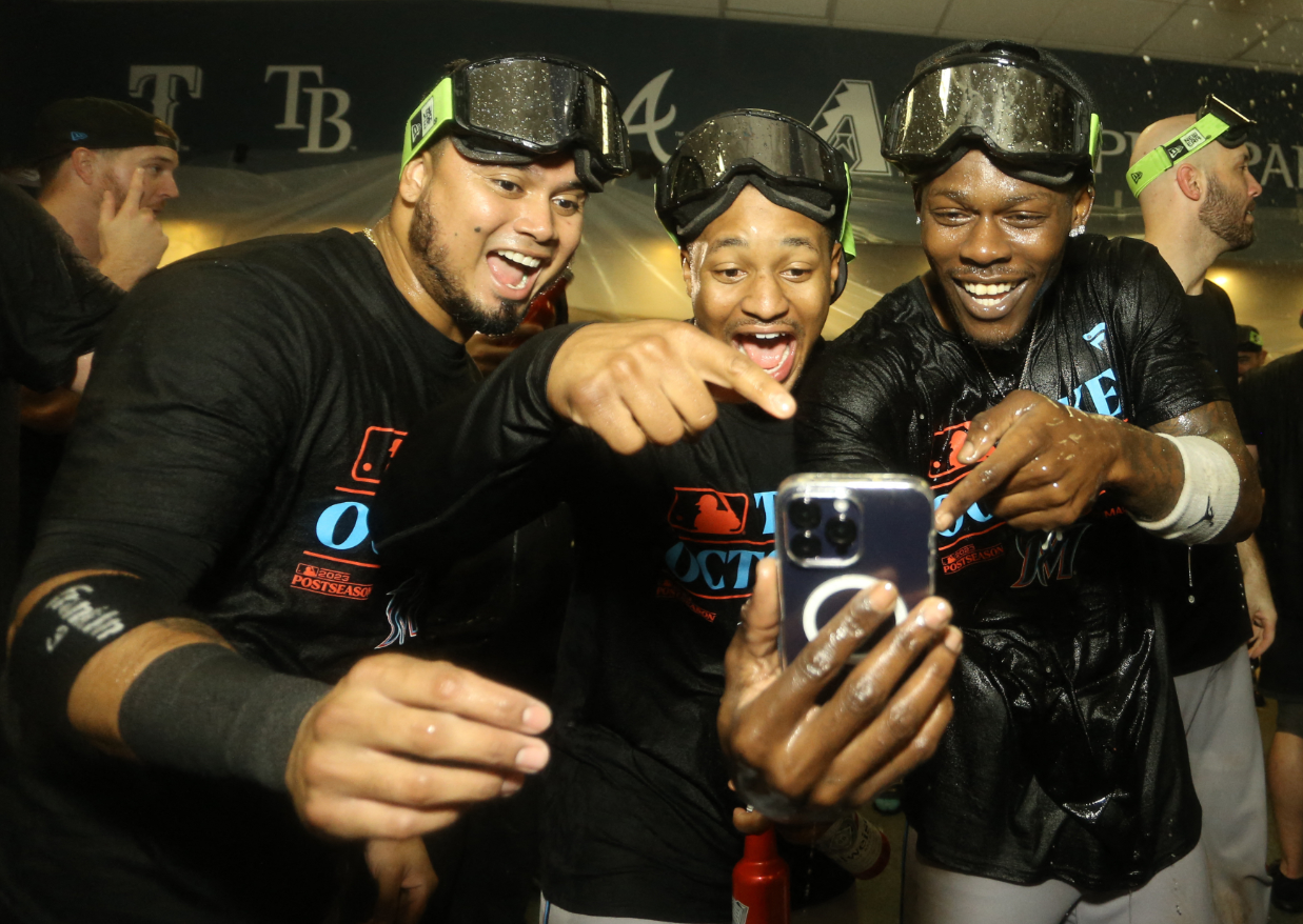 Miami Marlins Luis Arraez, left, Xavier Edwards, center, and Jazz Chisholm Jr., right, celebrate in the locker room after defeating the Pittsburgh Pirates at PNC Park to secure a berth in the 2023 MLB playoffs in Pittsburgh, Pennsylvania, Sept. 30, 2023.