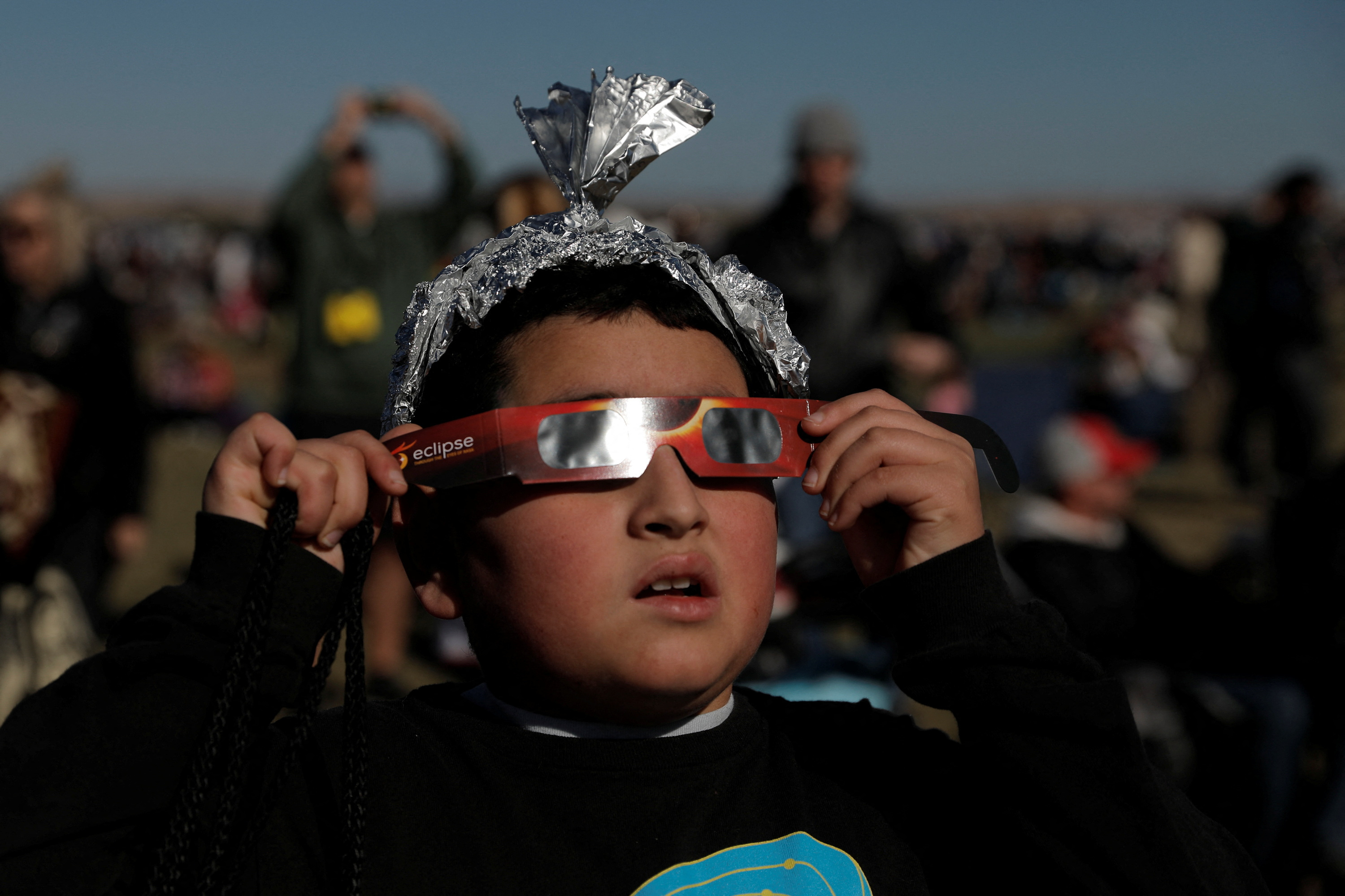 Ten-year-old Ezra Martinez watches the annular solar eclipse at the Albuquerque International Balloon Fiesta in Albuquerque, New Mexico, U.S., October 14, 2023. REUTERS/Adria Malcolm