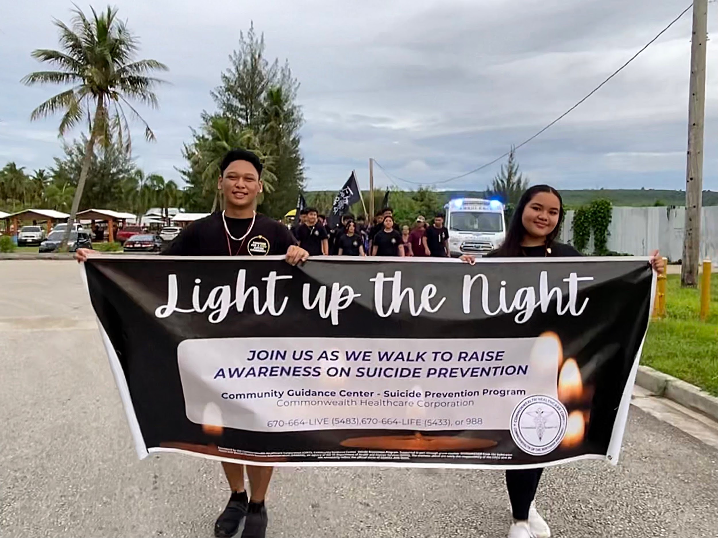 C/1SG Abiel Erickson and C/MAJ Ysabella Palacios hold up the Light Up the Night sign.