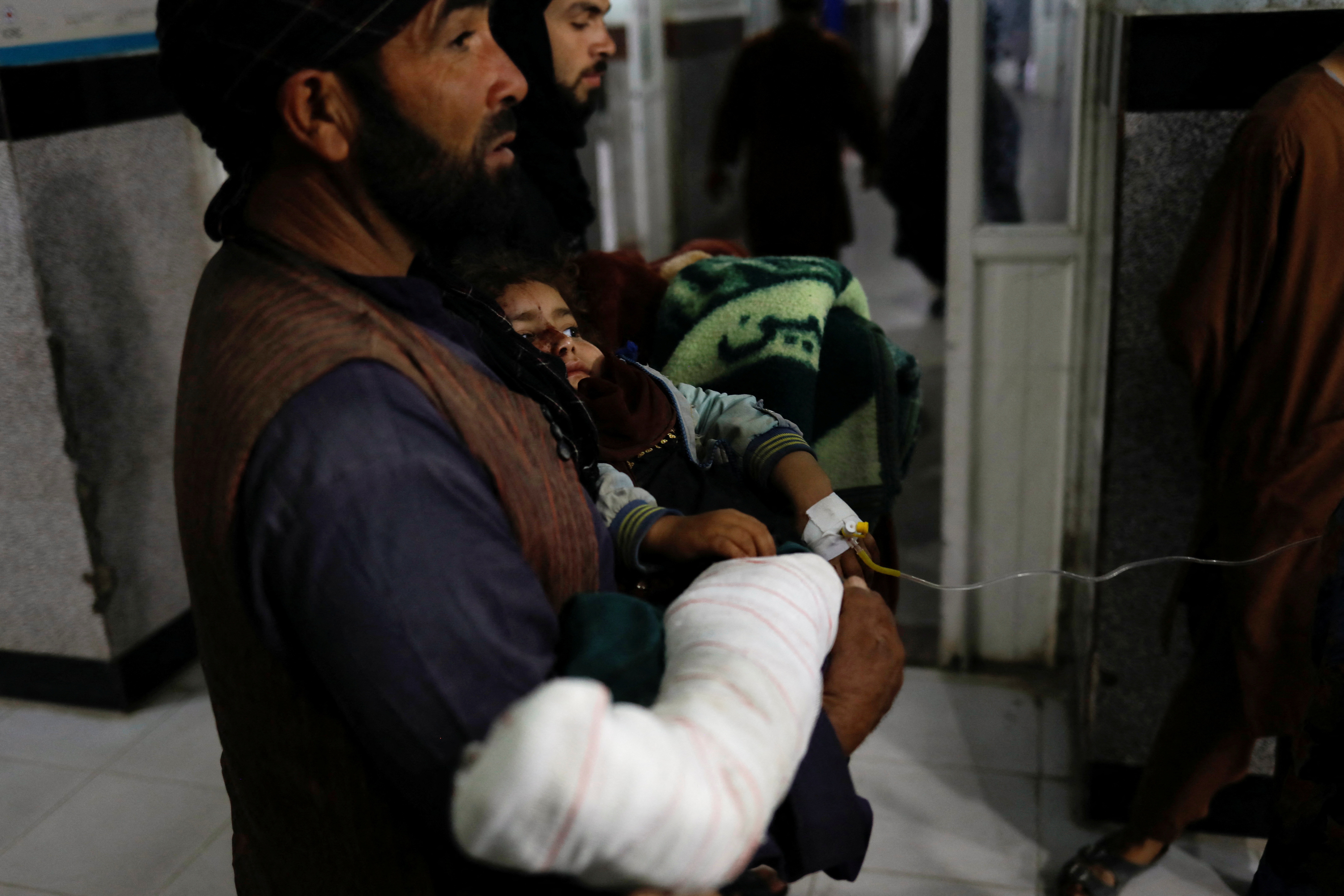 A victim of an earthquake carries his child to a hospital in Herat, Afghanistan October 8, 2023. 