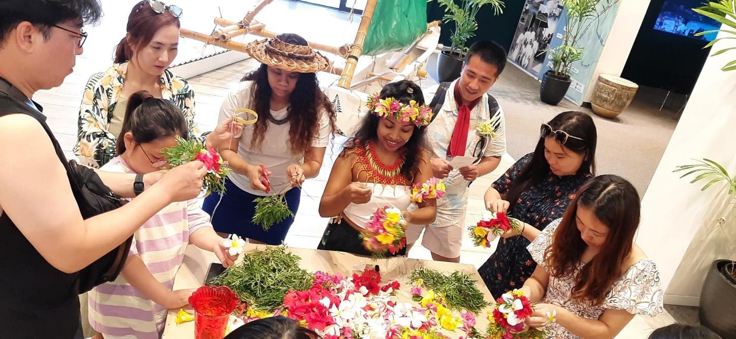 Florence Peter, fourth from right, teaches “mwar” (floral head lei) making on Sept. 28, 2023, at the Marianas Experience at T Galleria in Saipan.