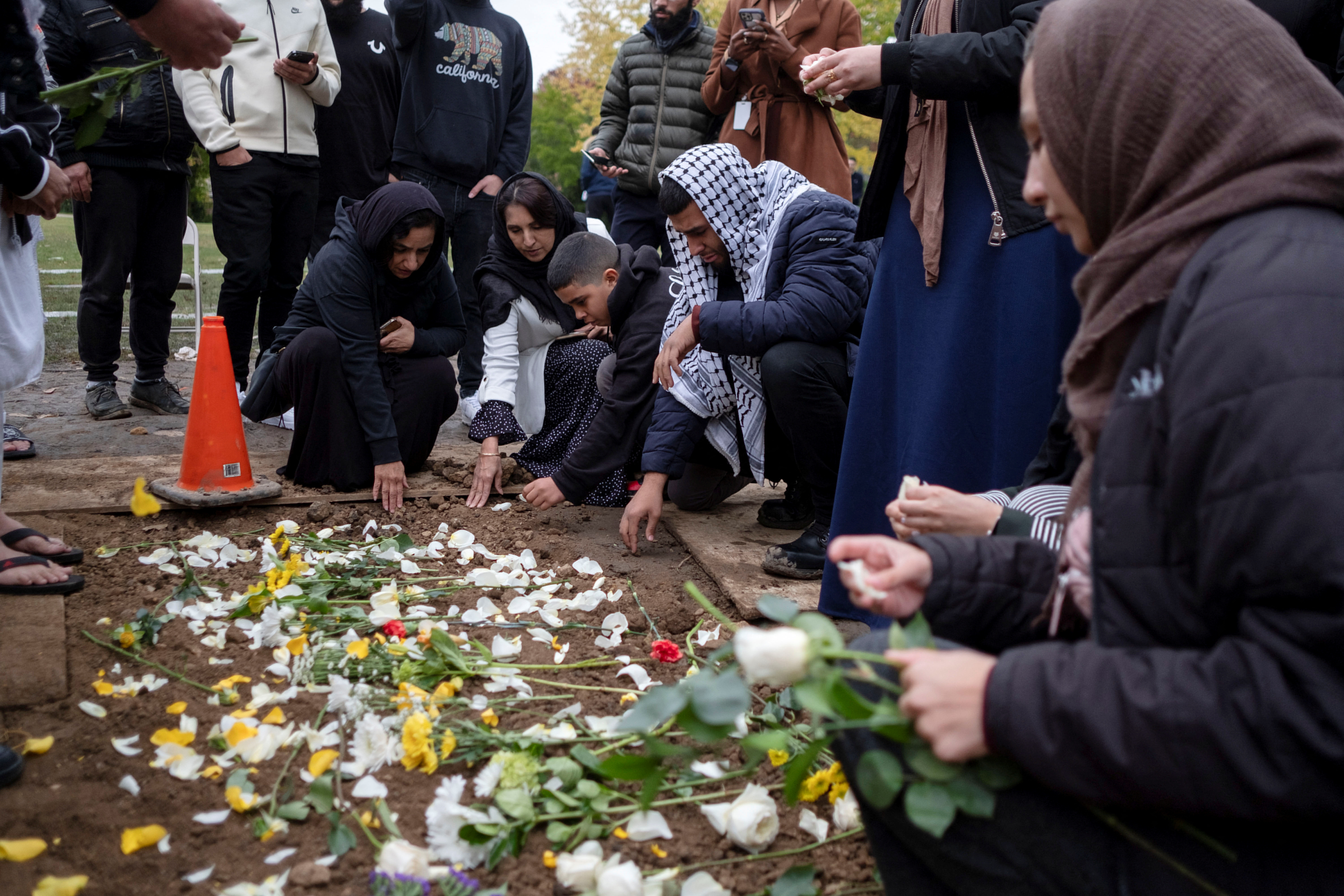 Mourners place flowers at the grave of Wadea Al-Fayoume at Parkholm Cemetery where the burial took place of Wadea Al-Fayoume, 6, a Muslim boy who according to police was stabbed to death in an attack that targeted him and his mother for their religion and as a response to the war between Israel and Hamas, in LaGrange, Illinois, U.S. October 16, 2023. 