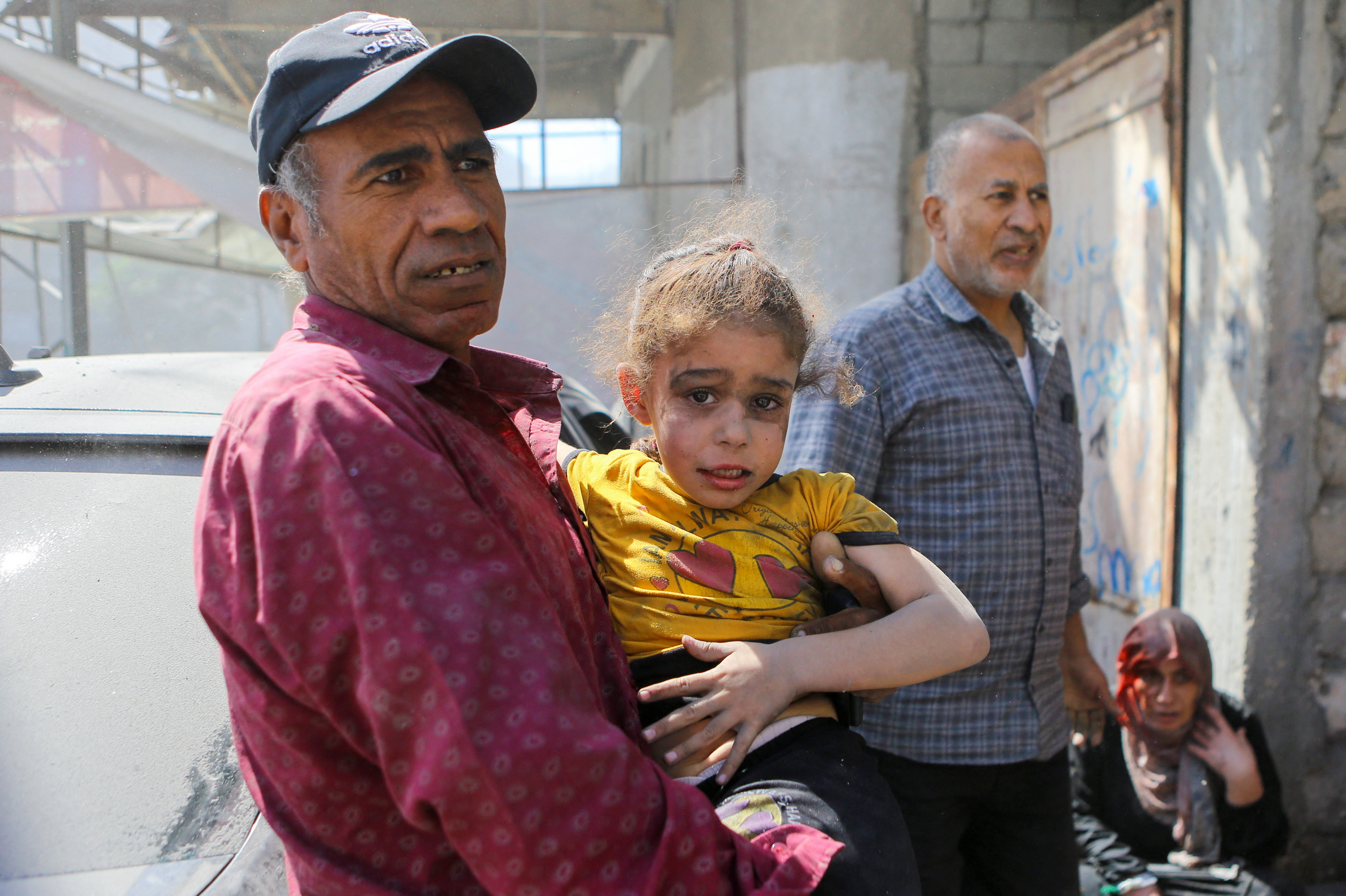 A Palestinian man carries a girl hurt in Israeli strikes in Gaza City October 15, 2023. REUTERS/Mutasem Murtaja
