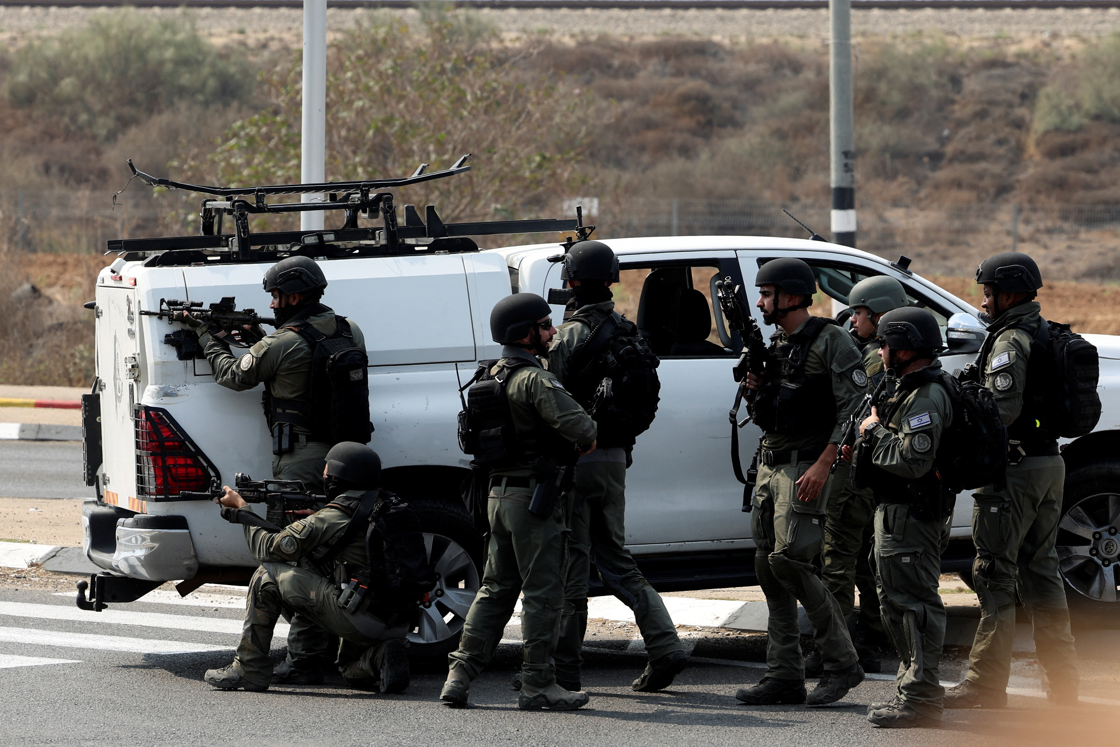 Israeli security take position on a road following a mass infiltration by Hamas gunmen from the Gaza Strip, near Sderot in southern Israel October 8, 2023. 