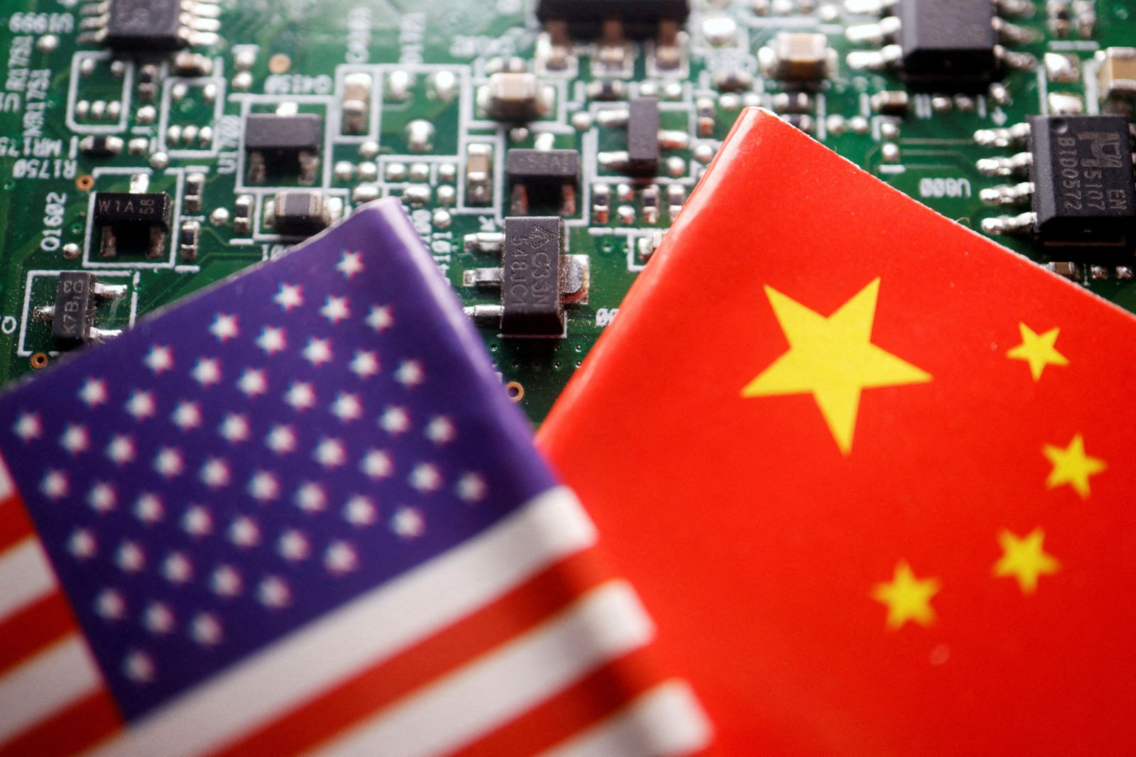 Flags of China and U.S. are displayed on a printed circuit board with semiconductor chips, in this illustration picture taken February 17, 2023.