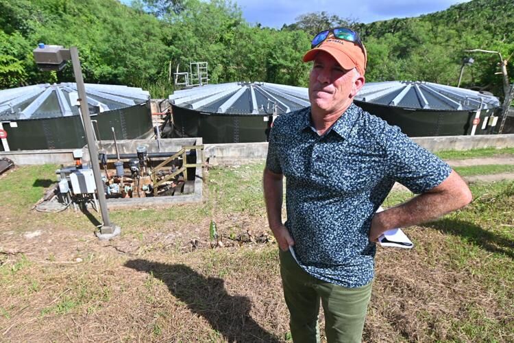 Gershman, Brickner & Bratton Inc. receiver representative Chris Lund stands in front of three leachate tanks during a site visit to the Ordot dump on Thursday, Nov. 9, 2023, in Ordot.   