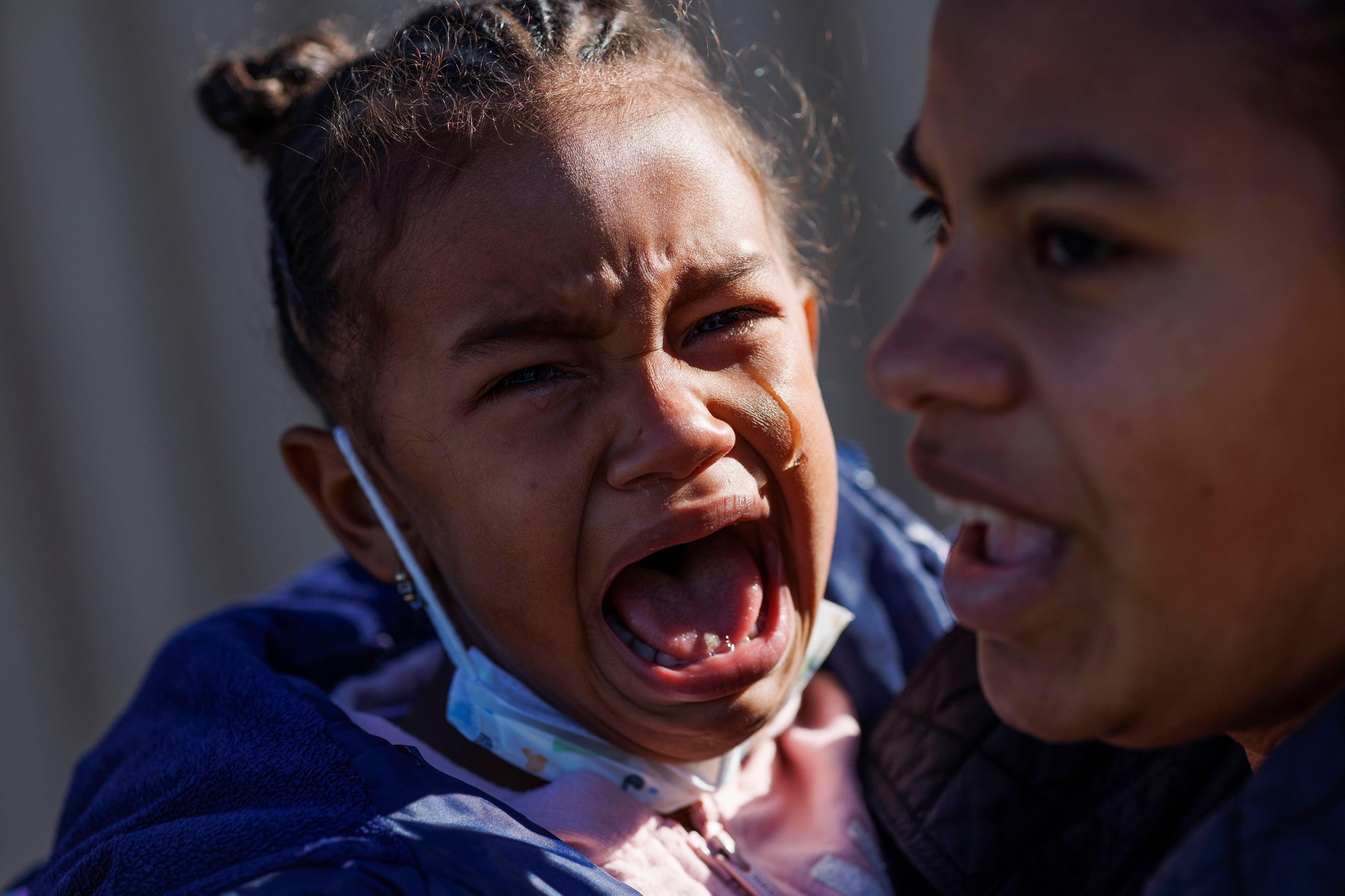 Jessana Malaue holds daughter Jessmar as she cries before they near their shelter near Pilsen after buying food at a WIC grocery, Nov. 10, 2023 in Chicago. Jessmar cried and told her mother she didn’t want to go inside.