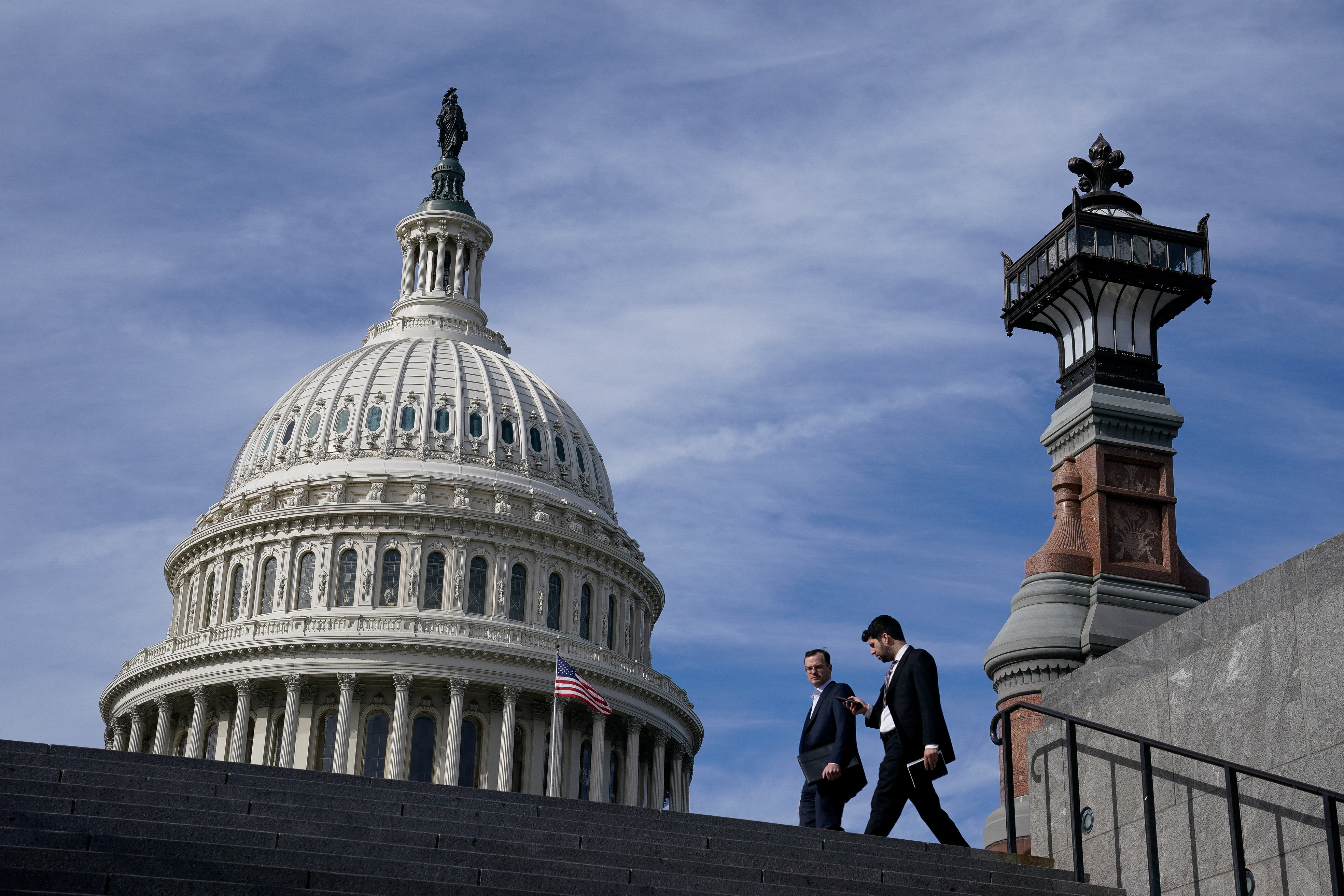 People walk past the U.S. Capitol building in Washington, U.S., November 15, 2023. 