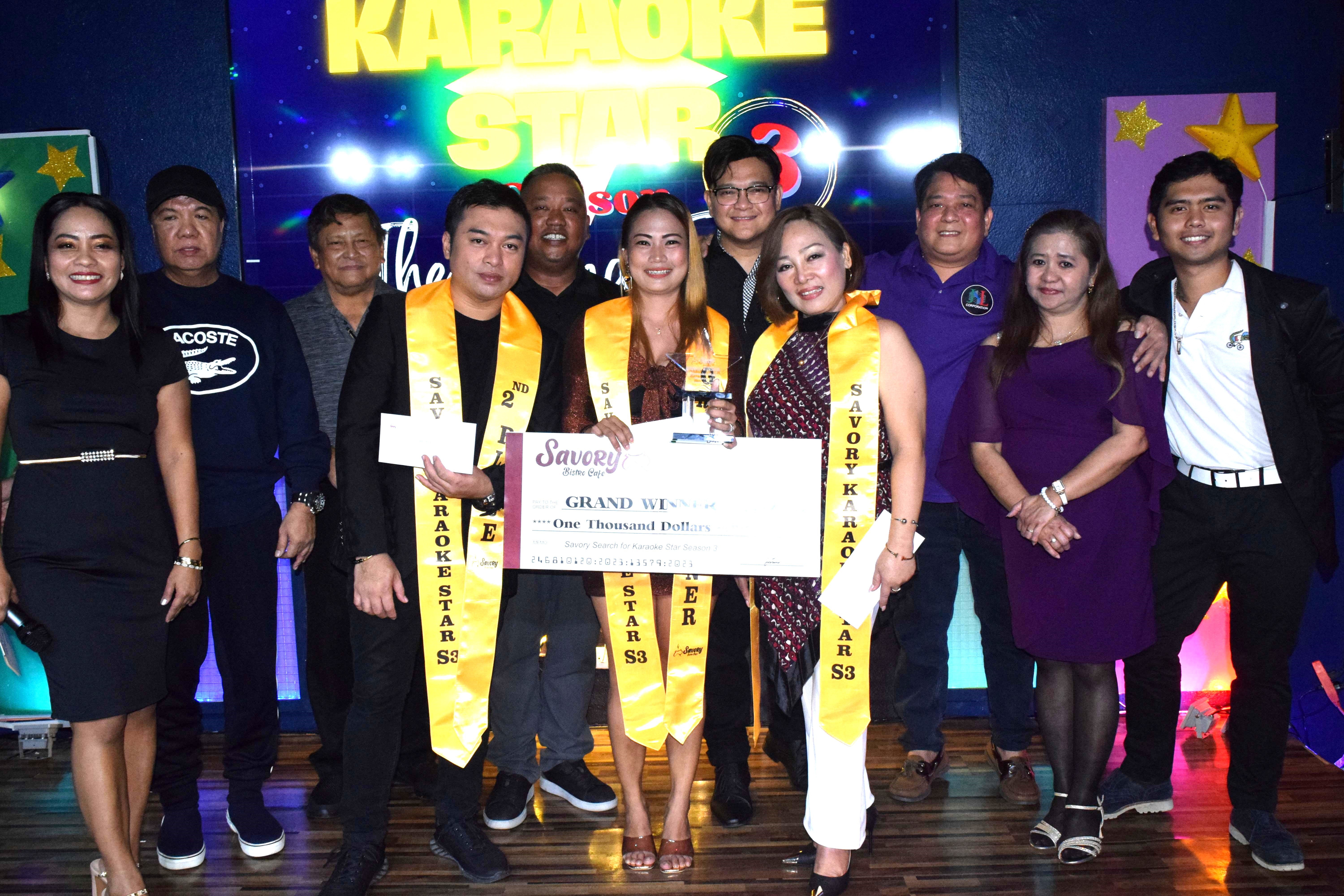 Savory Search for Karaoke Star winner Jessel Antonio, center, first runner-up Bath Ramos, fourth right, and second runner up, Robby Murillo, fourth left, with Savory Bistro Café president Jennifer Elayda, and the competition judges on Friday.