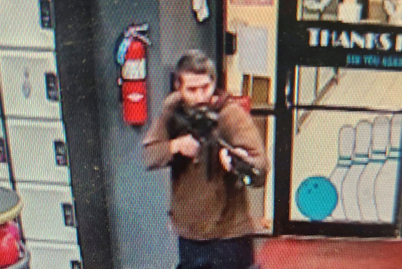 A man identified as a suspect by police points what appears to be a semiautomatic rifle, in Lewiston, Maine, U.S., October 25, 2023. 