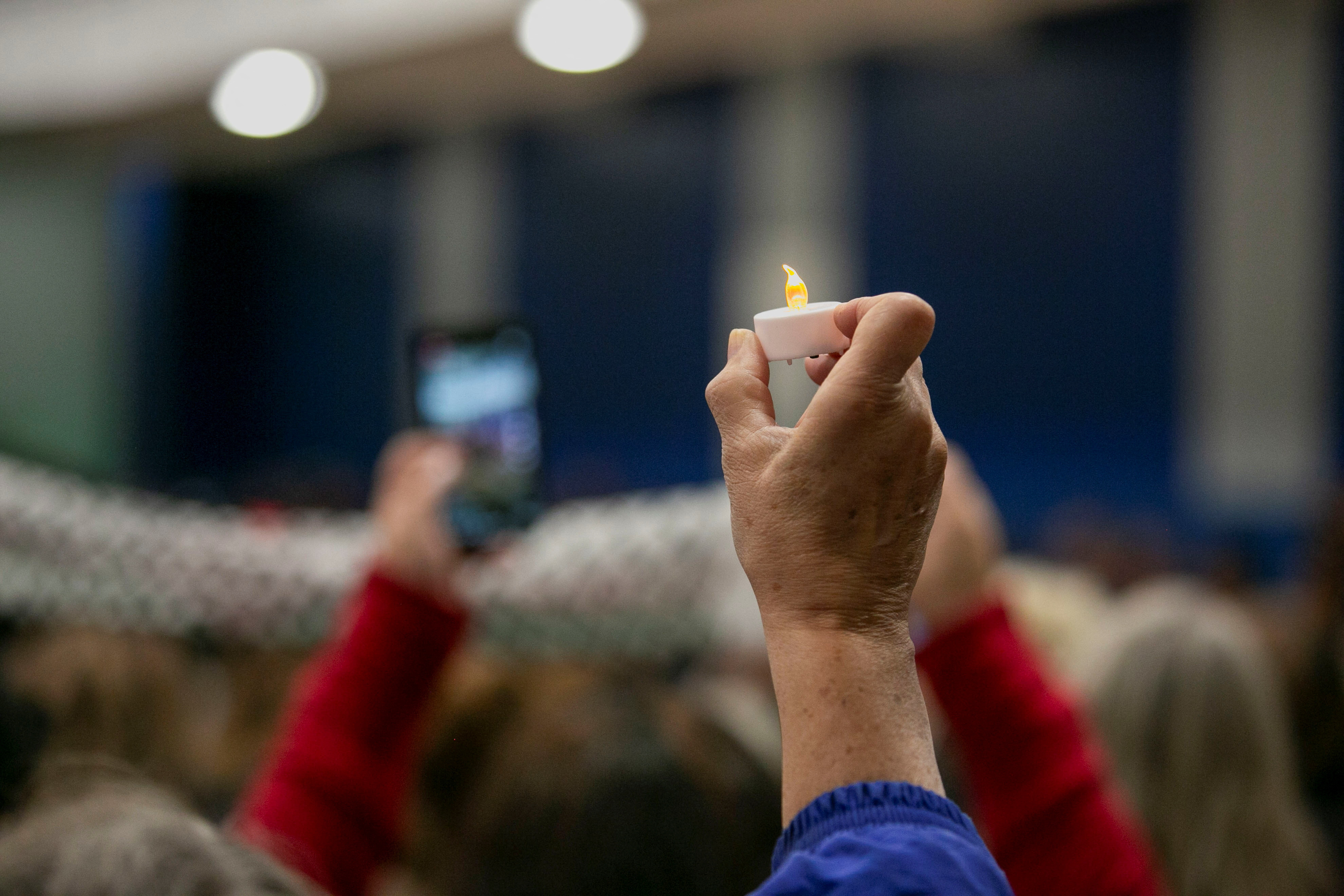 A mourner holds a candle at a vigil service at the Prairie Activity & Recreation Center for Wadea Al-Fayoume, 6, a Muslim boy who according to police was stabbed to death in an attack that targeted him and his mother for their religion and as a response to the war between Israel and Hamas, in Plainfield, Illinois, U.S. October 17, 2023. 