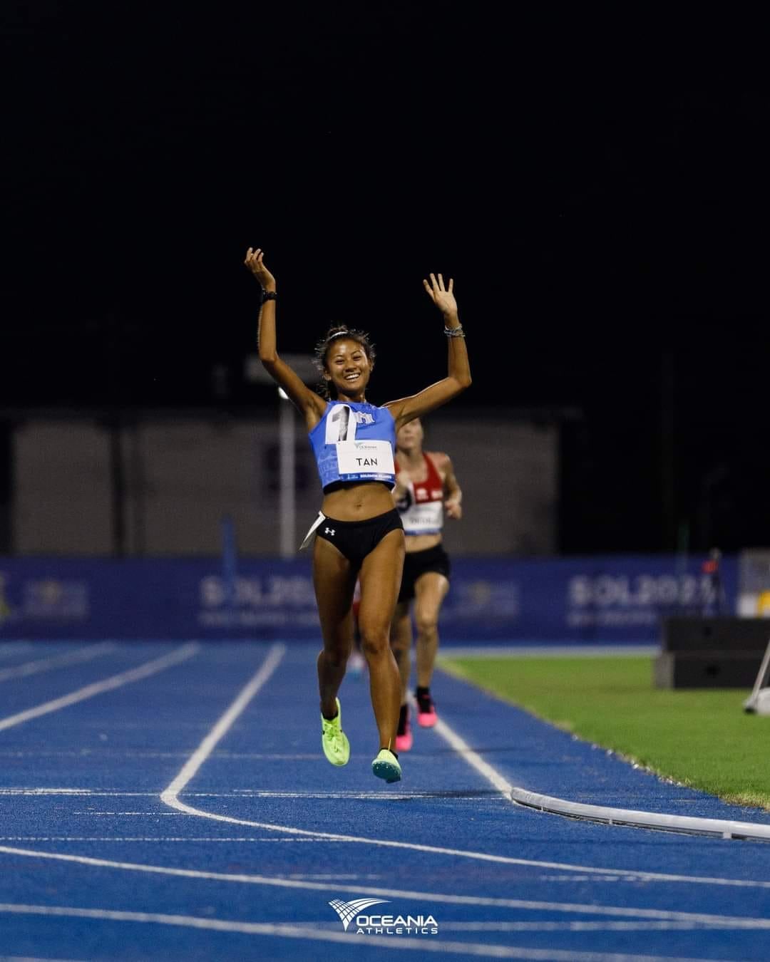 Tania Tan celebrates as she crosses the finish line to win the gold medal in the women’s 5000m event and set a new record  Monday in the 2023 Pacific Games in Honiara, the Solomon Islands.