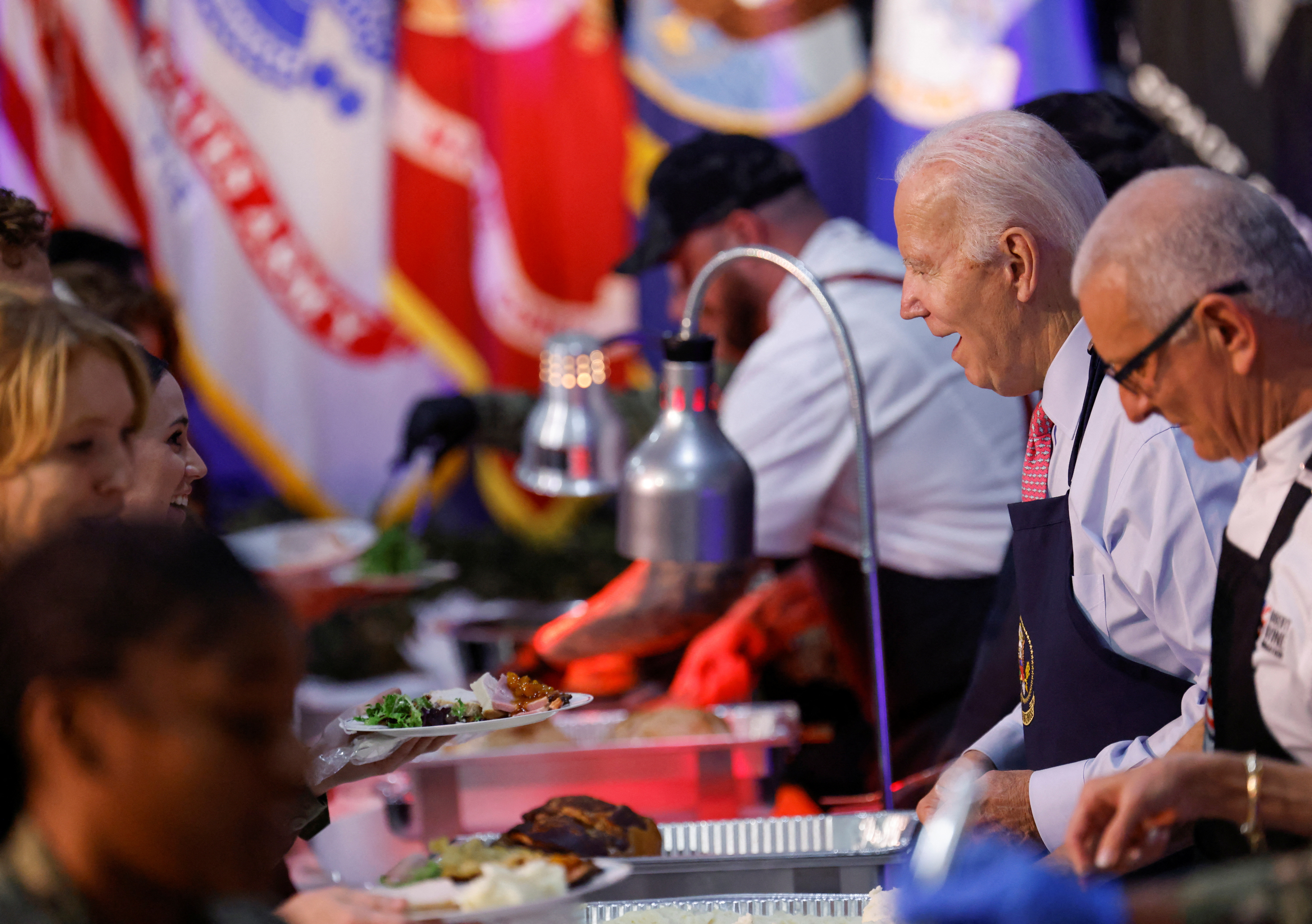 U.S. President Joe Biden serves food to service members and their families during a "Friendsgiving" event ahead of the Thanksgiving holiday at Naval Station Norfolk in Norfolk, Virginia, U.S., November 19, 2023. 