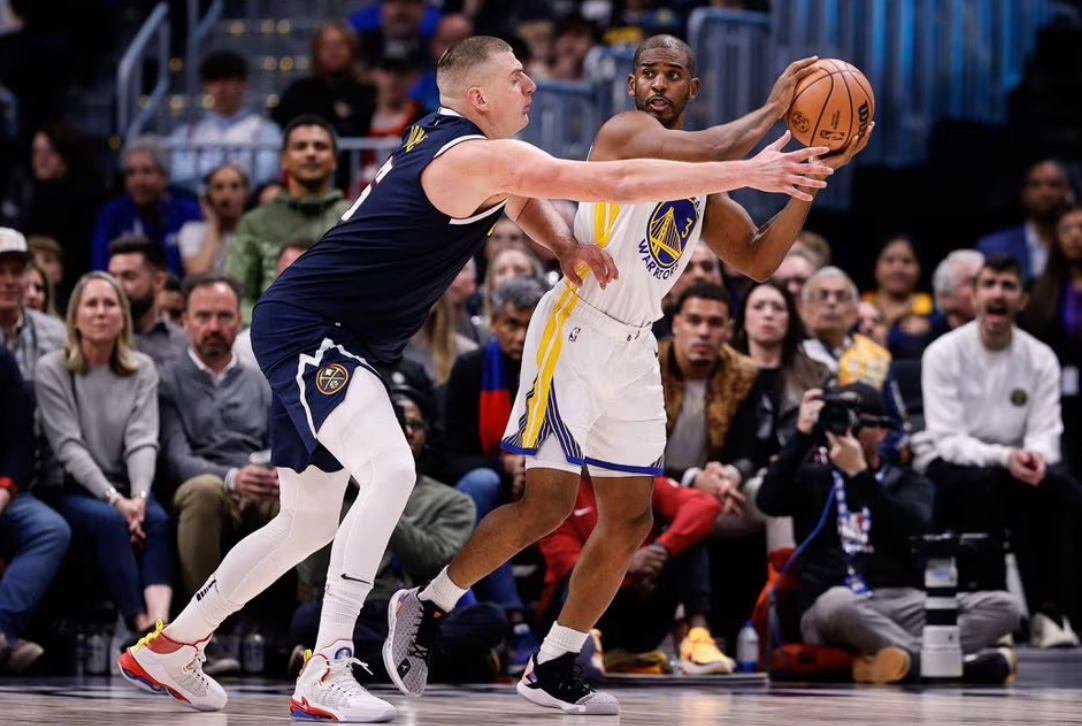 Golden State Warriors guard Chris Paul (3) looks to pass the ball under pressure from Denver Nuggets center Nikola Jokic (15) in the fourth quarter at Ball Arena in Denver, Colorado, Nov 8, 2023.