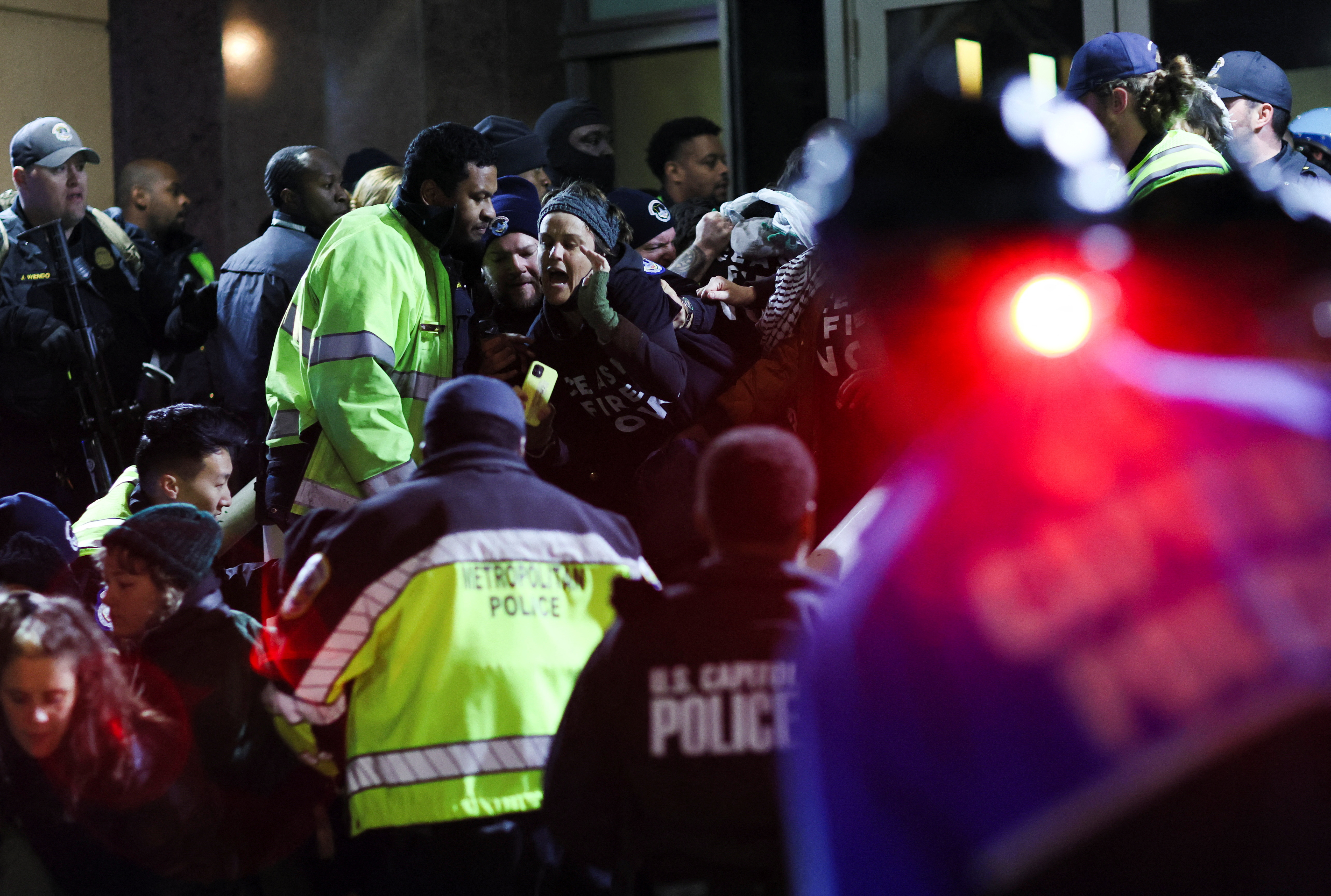 Police remove demonstrators blocking the entrance to the Democratic National Headquarters during a multi-denominational event hosted by the Democratic Socialists of America, IfNotNow Movement and Jewish Voice for Peace calling for a ceasefire in the conflict between Israel and Palestinian Islamist group Hamas, in Washington, U.S. November 15, 2023. 