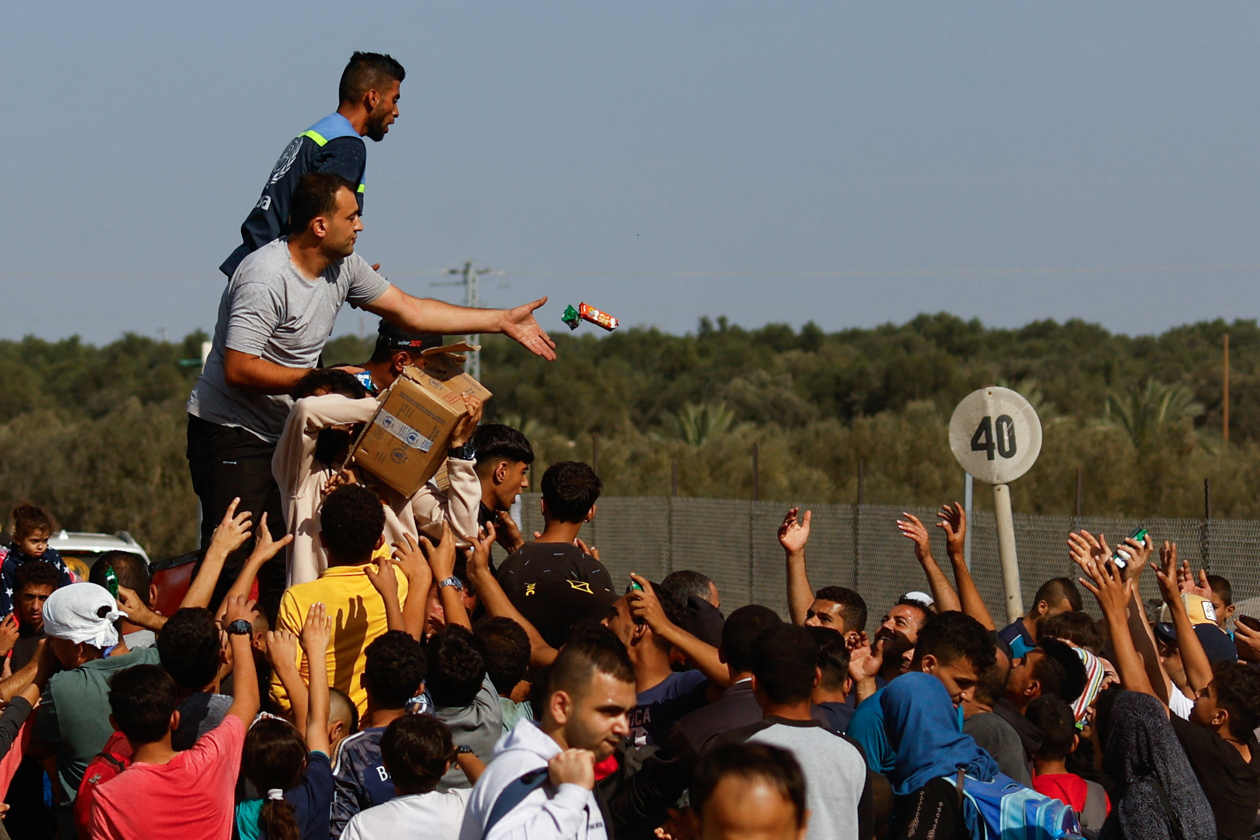Aid is distributed while Palestinians fleeing north Gaza move southward as Israeli tanks roll deeper into the enclave, in the central Gaza Strip, November 10, 2023. 