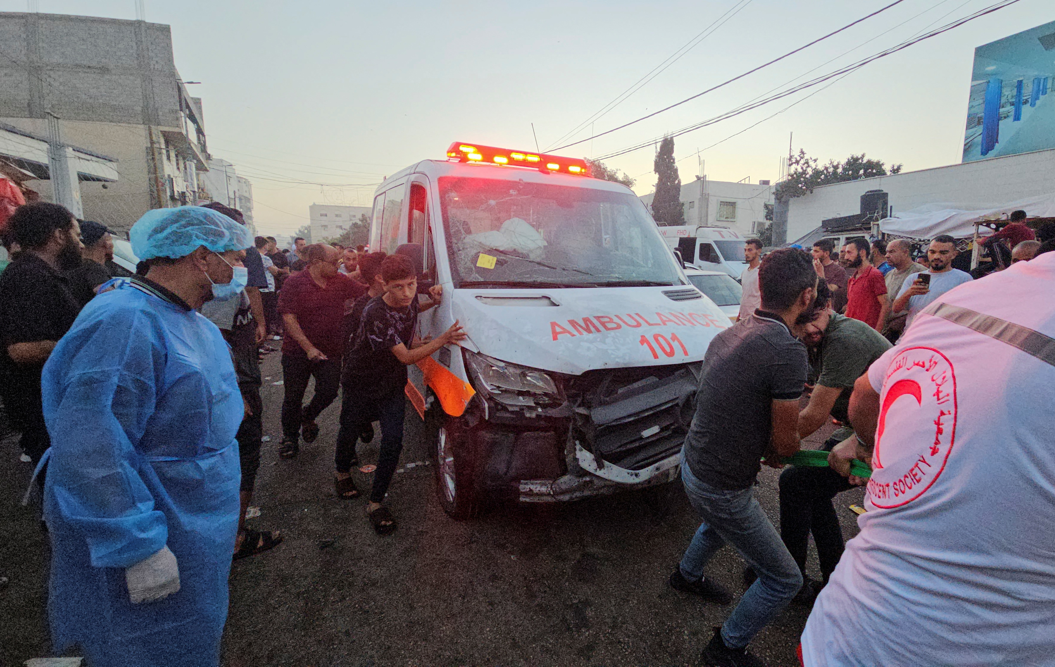 Palestinians pull an ambulance after a convoy of ambulances was hit, at the entrance of Shifa hospital in Gaza City, November 3, 2023. 