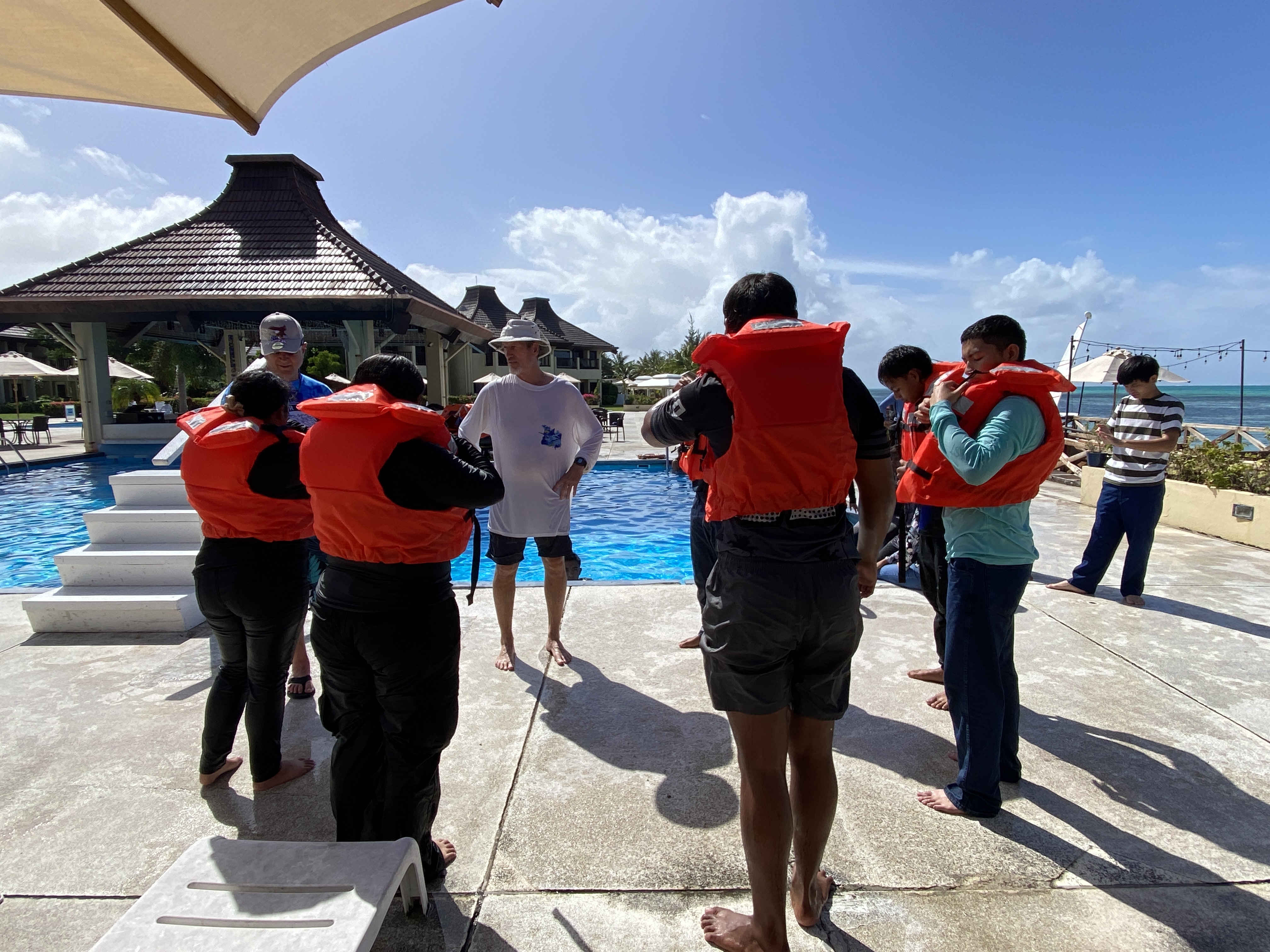 Capt. Michael Bacher, center, instructs students regarding proper donning of life jackets.