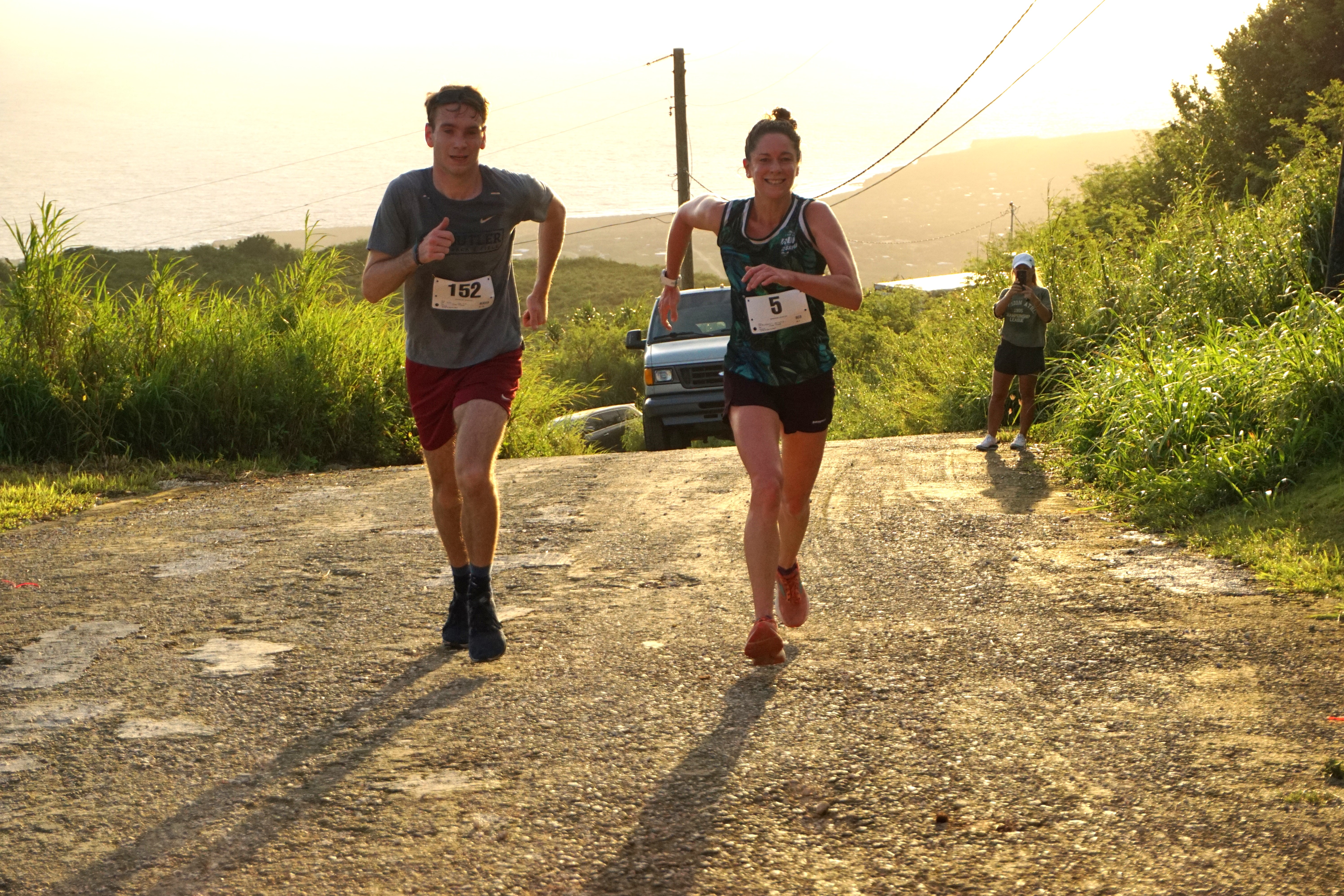 Lily Muldoon, right, smiles as she crosses the finish line of the 2023 NMA Mt. Tapochao Turkey Trot on Thursday.