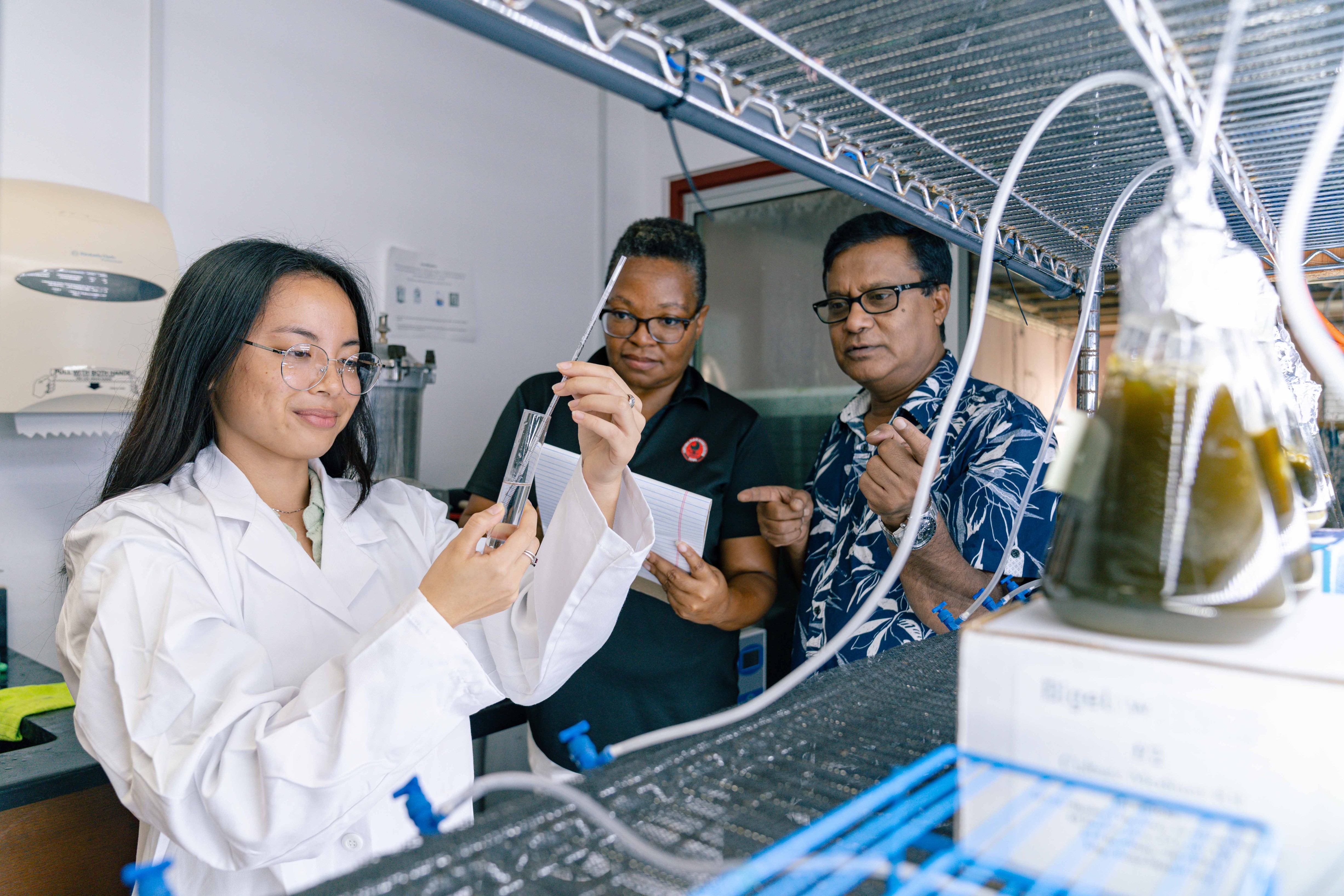 A student engages in hands-on learning during a laboratory testing session, guided by NextGen Project Director and Professor/State Program and Food Science Leader Dr. Zaidul Sarker and NextGen Program Manager Karim Johnson at the Northern Marianas College- Cooperative Research, Extension, and Education Services’ Center for Aquaculture Development.