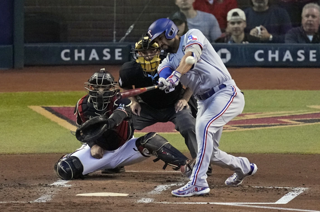 Texas Rangers’ Marcus Semien hits a two-run triple as Arizona Diamondbacks catcher Gabriel Moreno reaches for the pitch during the second inning in Game 4 of the baseball World Series Tuesday, Oct. 31, 2023, in Phoenix.