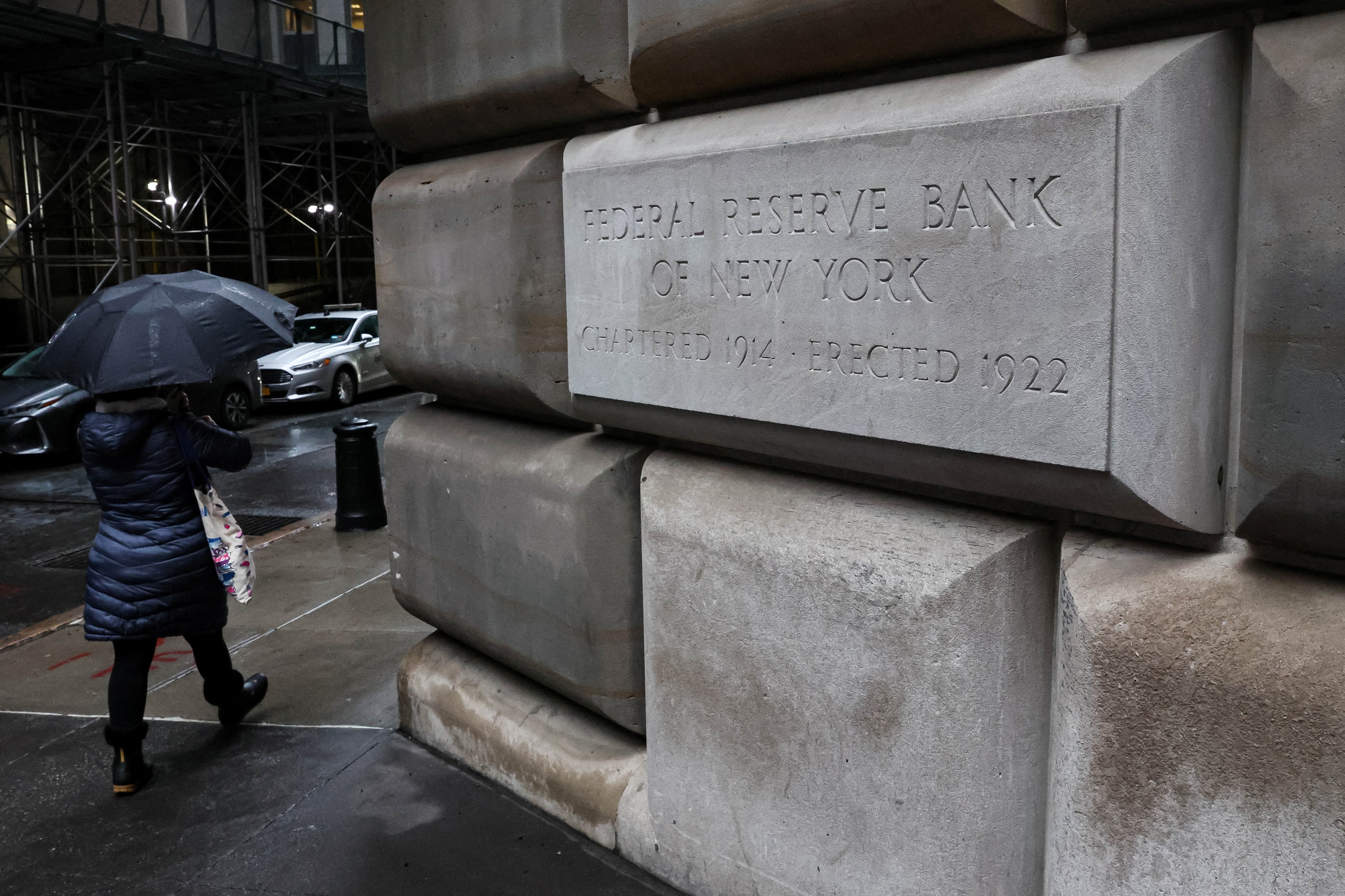 A woman passes by The Federal Reserve Bank of New York in New York City, U.S., March 13, 2023. 