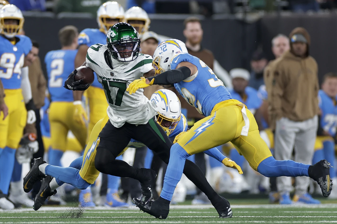 New York Jets wide receiver Garrett Wilson tries to avoid a tackle by Los Angeles Chargers safety Alohi Gilman during the first quarter of an NFL game, Monday, Nov. 6, 2023 in East Rutherford, N.J.