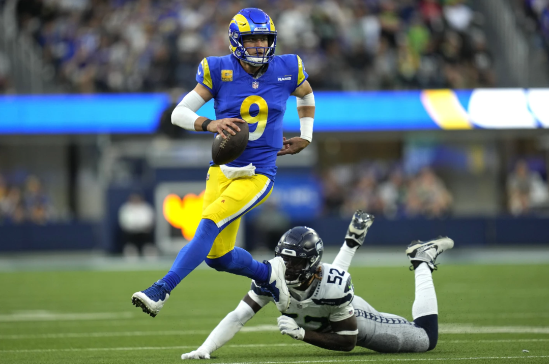 Los Angeles Rams quarterback Matthew Stafford (9) runs the ball after evading a tackle from Seattle Seahawks linebacker Darrell Taylor (52) during the second half of an NFL game Sunday, Nov. 19, 2023, in Inglewood, Calif.