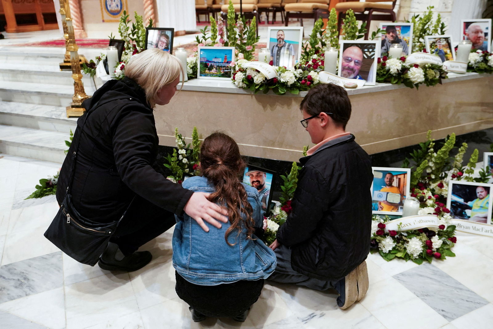 Mourners look at pictures of the victims during a vigil for the victims of the deadly mass shooting, at the Basilica of Saints Peter and Paul, in Lewiston, Maine, U.S., October 29, 2023. 