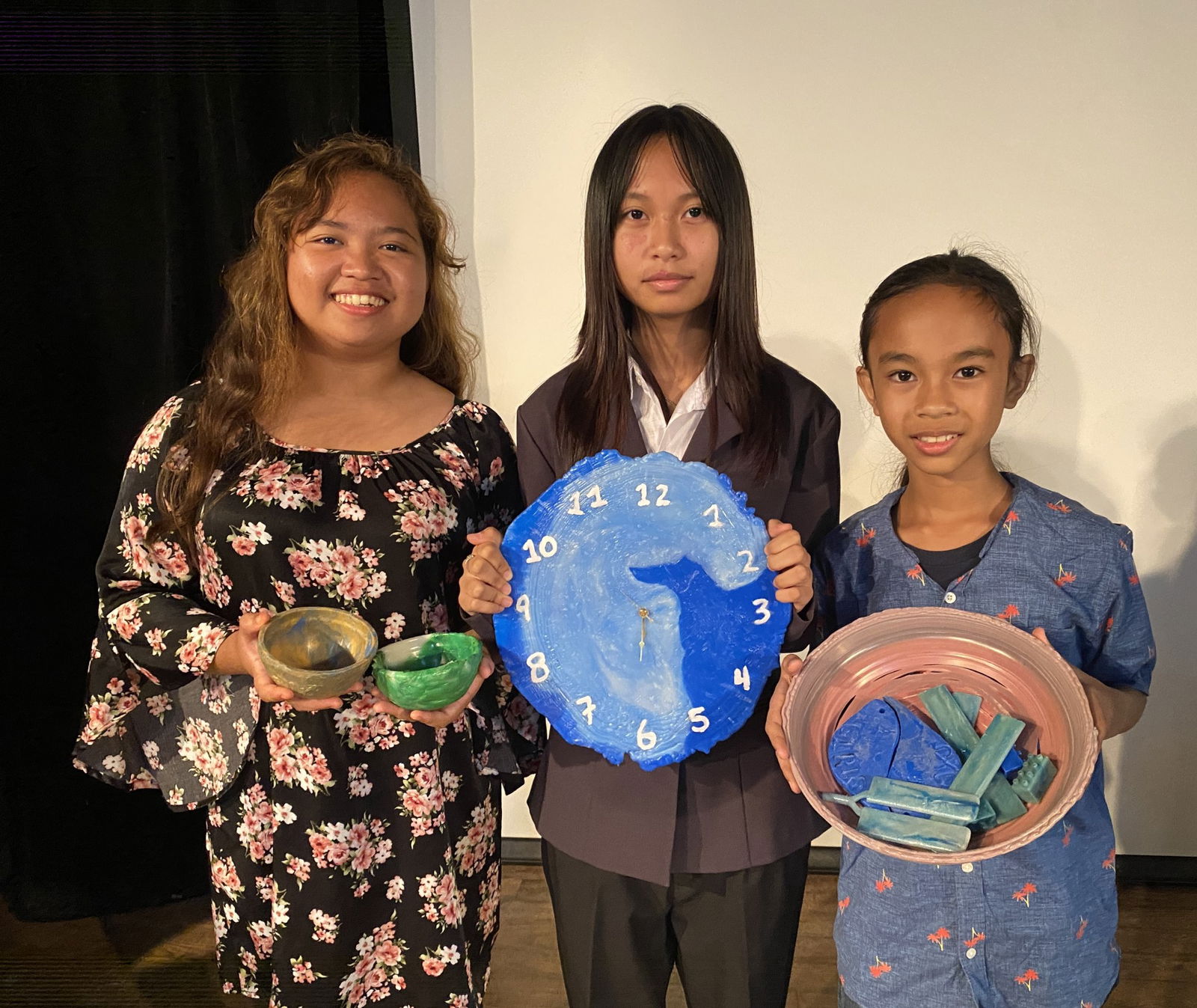 From left, Dandan Middle School students Althea Sogurilon, Ezdiane Jacolbe and John Alberto display recycled products they made with plastics collected at their school. DMS has a 3-in-1 recycling machine which allows users to create bowls and rulers pictured below. The clock was created with a custom mold fabricated by students.