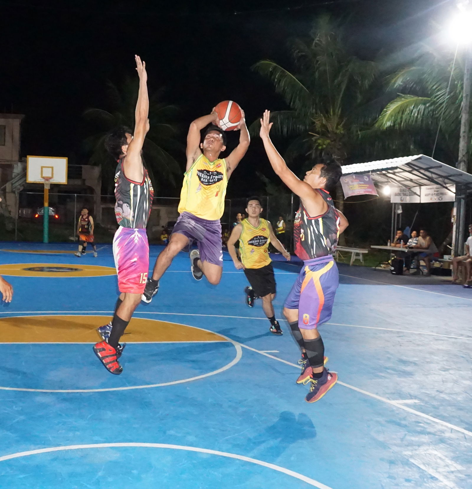 Bourbon Bar & Café’s Paul Manansala attempts to take the midrange shot between two defenders during a game of the 2023 Pacific Saipan Promo Invitational Basketball League at the Gualo Rai basketball court on Friday.