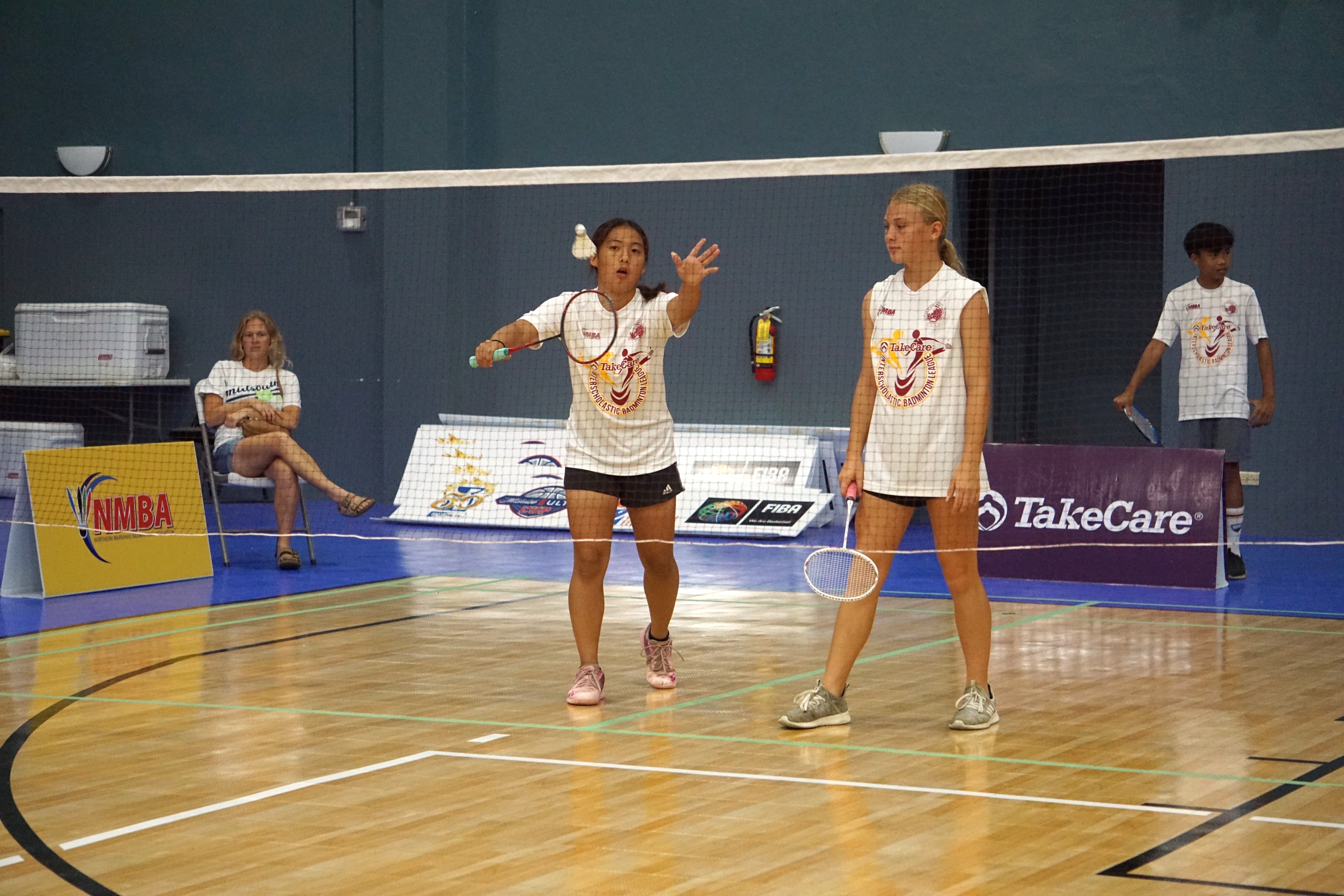 Saipan International School’s Lina Takugoshi makes the serve with her partner in the co-ed middle school division’s girls doubles event of the TakeCare Interscholastic Badminton League SY23-24 Saturday at the Ada gym.