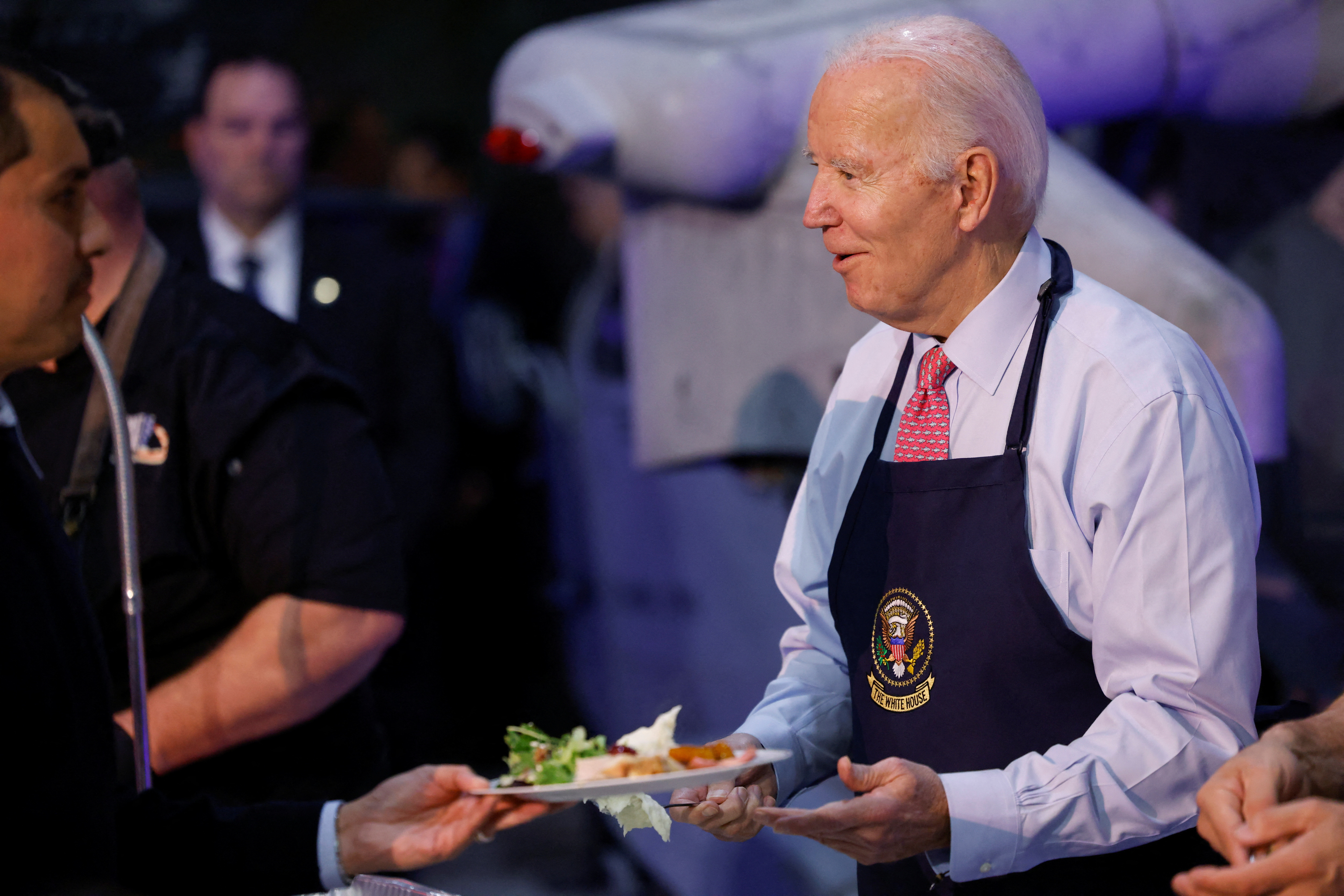 U.S. President Joe Biden serves food to service members and their families during a "Friendsgiving" event ahead of the Thanksgiving holiday at Naval Station Norfolk in Norfolk, Virginia, U.S., November 19, 2023. 