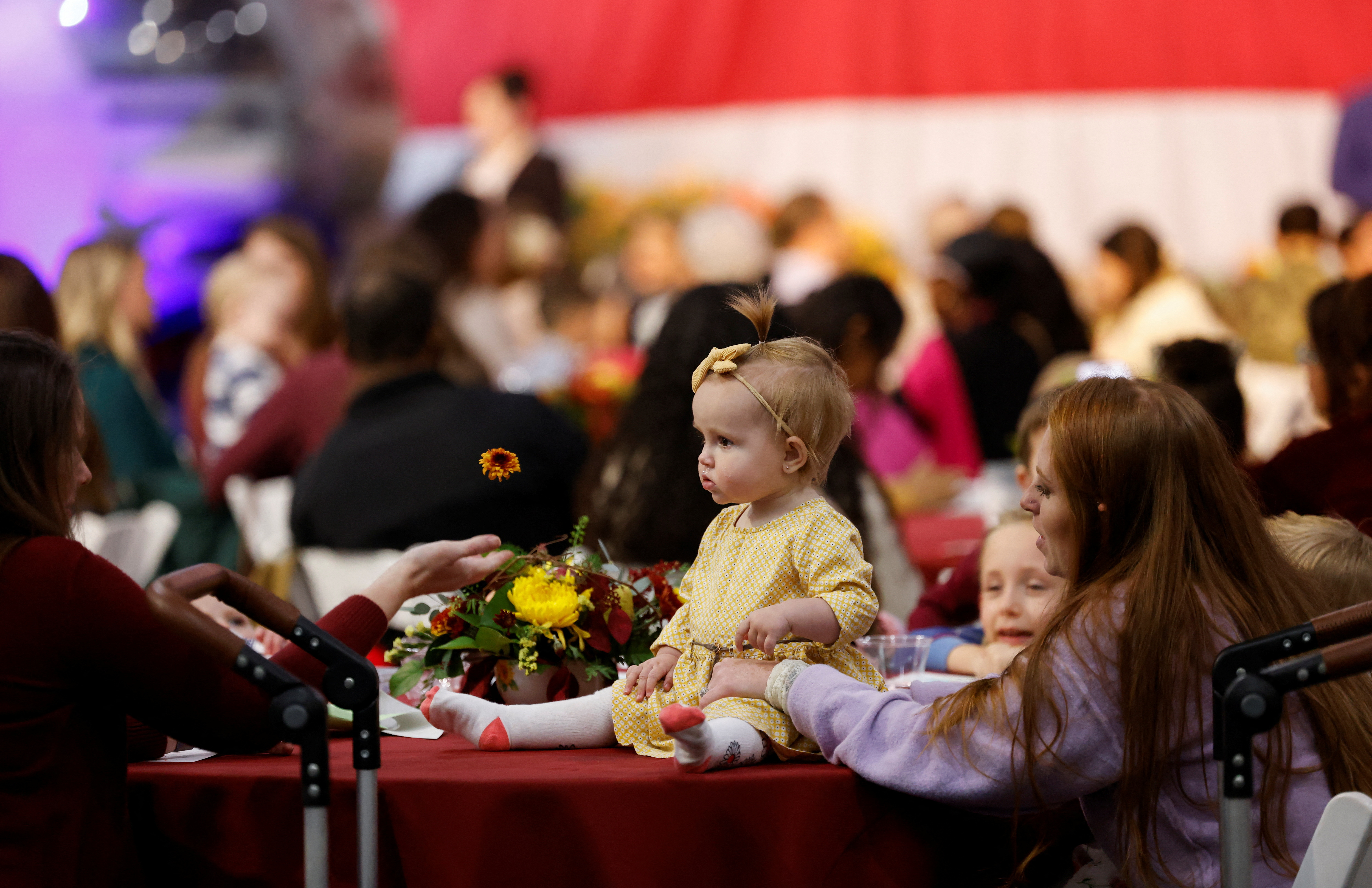 Military families wait before a meeting with U.S. President Joe Biden ahead of the Thanksgiving holiday during a "Friendsgiving" at Naval Station Norfolk in Norfolk, Virginia, U.S., November 19, 2023. 