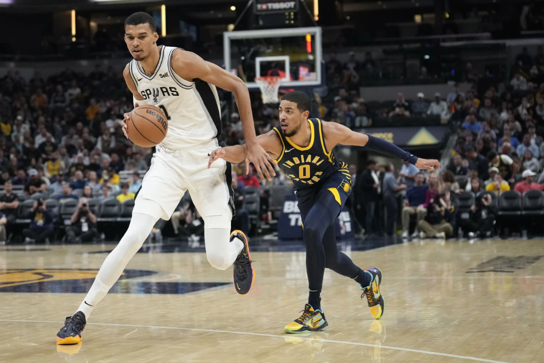 San Antonio Spurs center Victor Wembanyama goes around Indian Pacers guard Tyrese Haliburton during the second half of an NBA game in Indianapolis, Monday, Nov. 6, 2023.