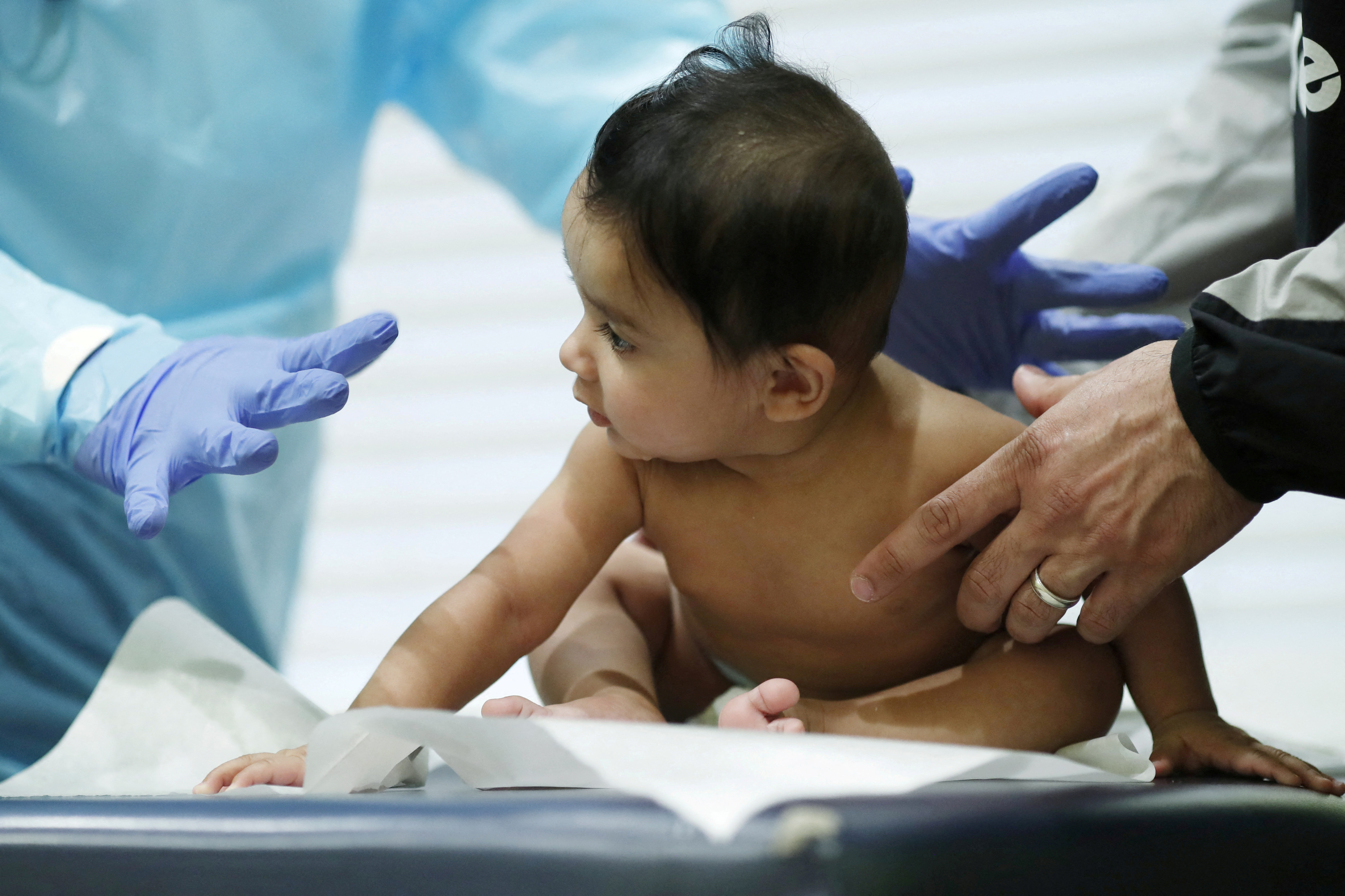 A doctor performs a routine checkup with a baby at his pediatric practice in Oyster Bay, New York, U.S., April 13, 2020. 