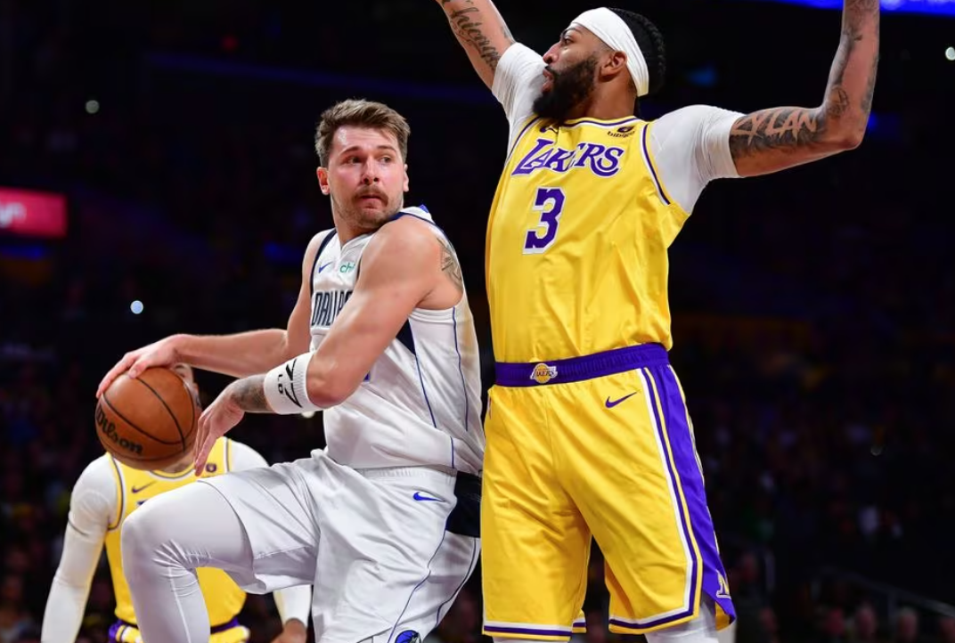 Dallas Mavericks guard Luka Doncic (77) passes the ball against Los Angeles Lakers forward Anthony Davis (3) during the first half at Crypto.com Arena in Los Angeles, California, Nov. 22, 2023.