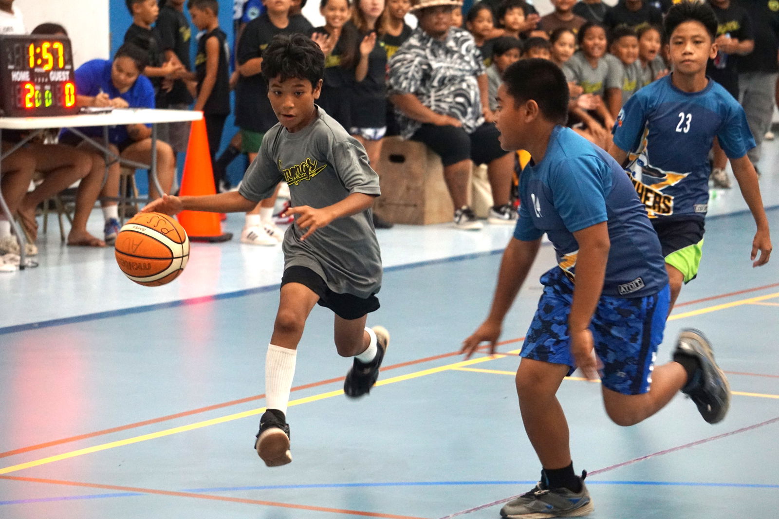 KOB 2's Tickson Cosmes dribbles down the court as a defender closes in during a co-ed elementary school division game of the IT&E Interscholastic Basketball League SY23-24 at the Marianas High School gym.