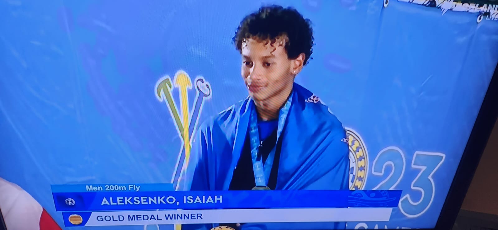 A screen grab of Isaiah Aleksenko during the livestreamed medal ceremony for the 200m butterfly event in the 2023 Pacific Games Wednesday night in Honiara, the Solomon Islands.