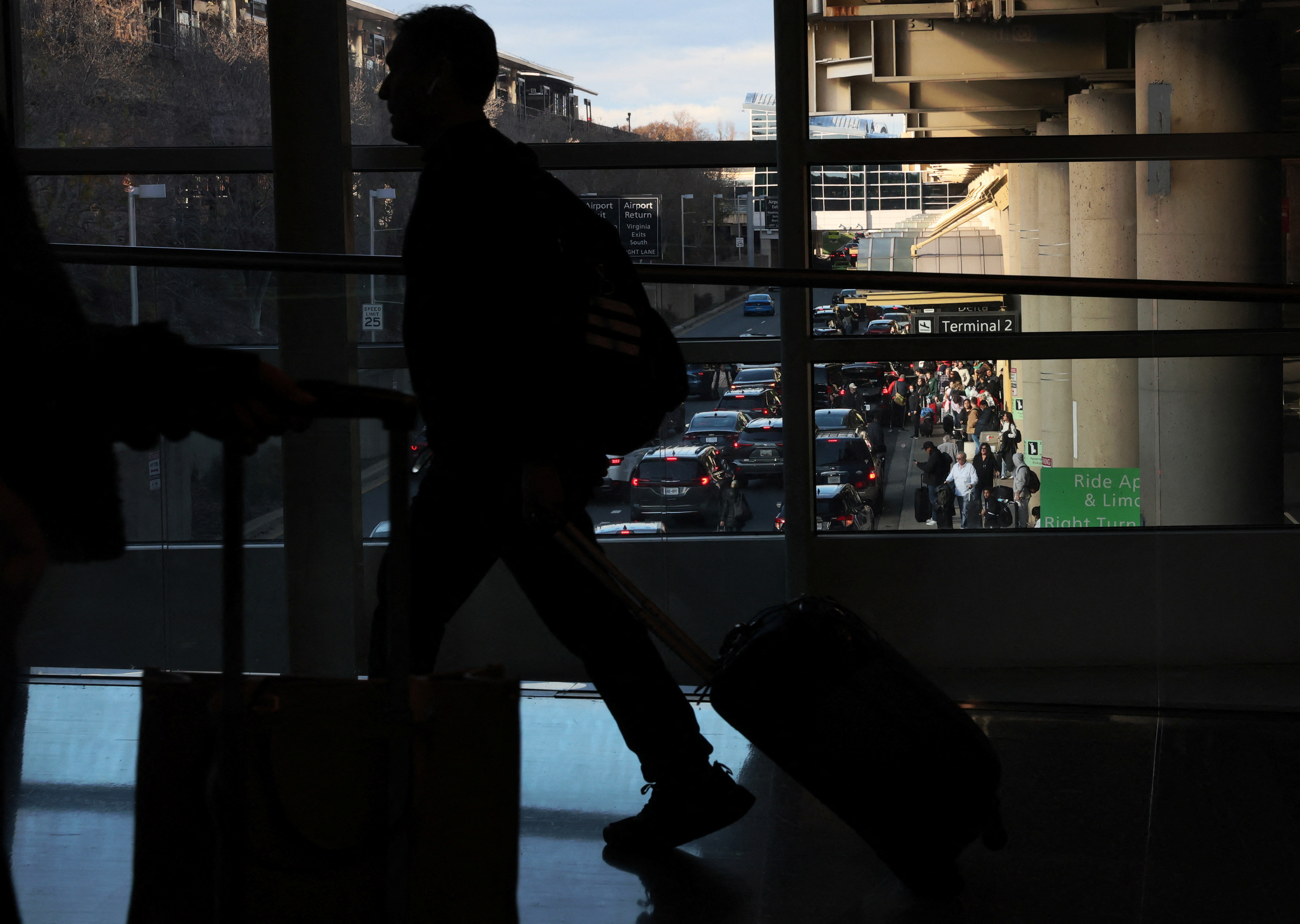 People wait to be picked up as others arrive at Ronald Reagan Washington National Airport ahead of the Thanksgiving holiday in Arlington, Virginia, U.S., November 22, 2023.