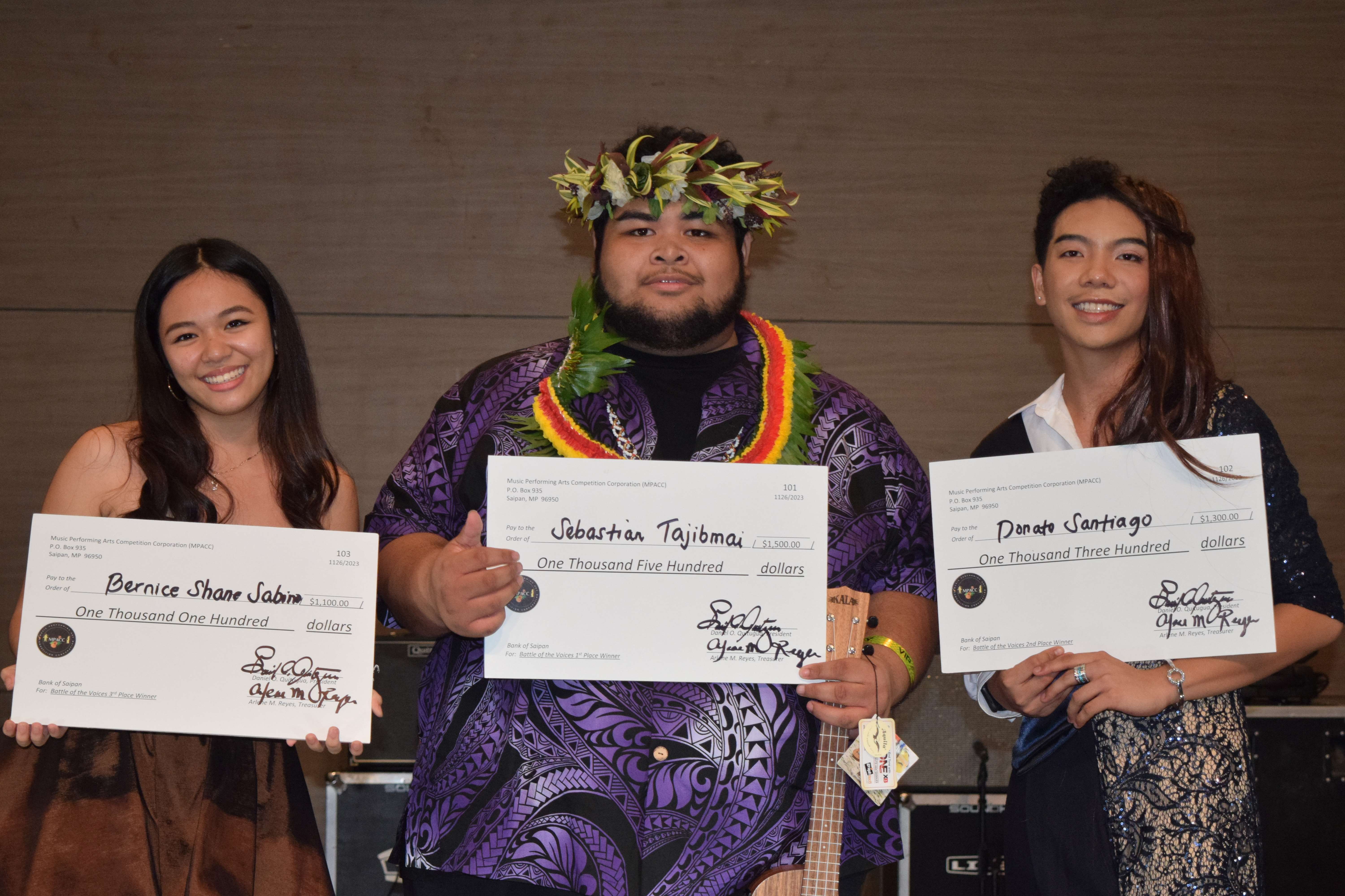 Marianas Got Talent’s top three winners, from left, Bernice Sabino, third prize; Sebastian Tajibmai, first prize; and Donato Santiago, third prize, hold ceremonial checksatSaipan World Resort's Taga Hall on Sunday.