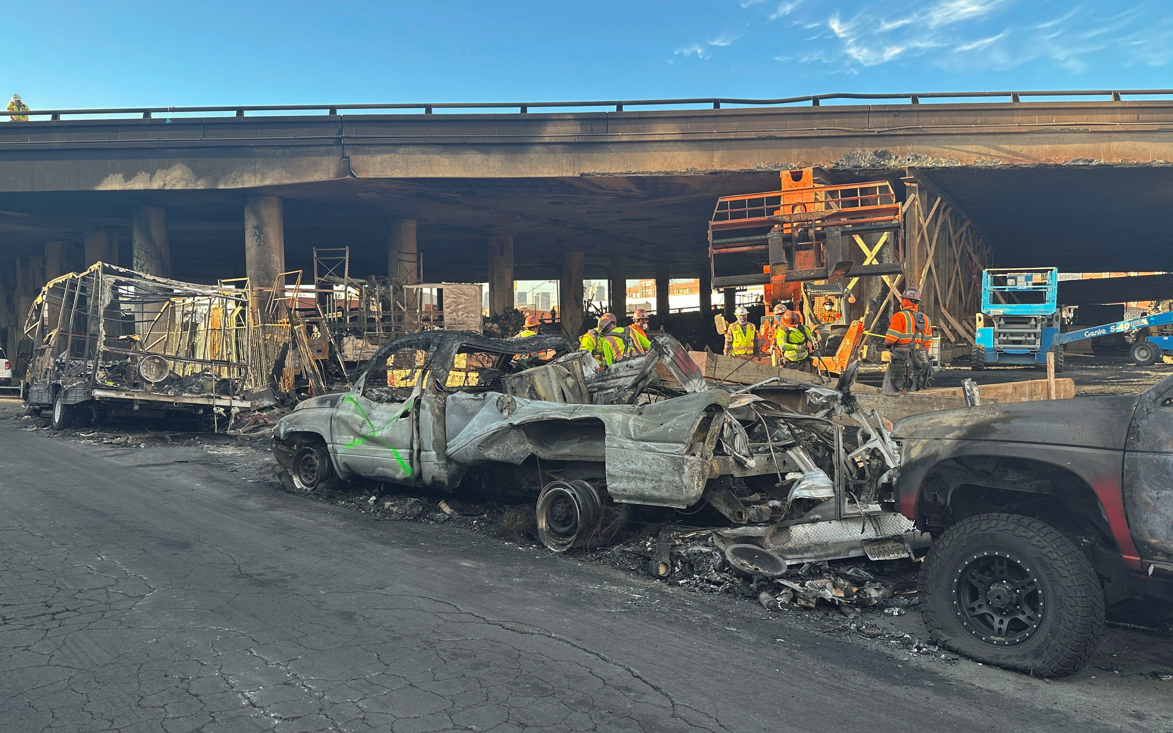 Crew members work in the area, where a fire erupted over the weekend, shutting down a heavily trafficked corridor in Los Angeles, California, U.S., November 13, 2023. 