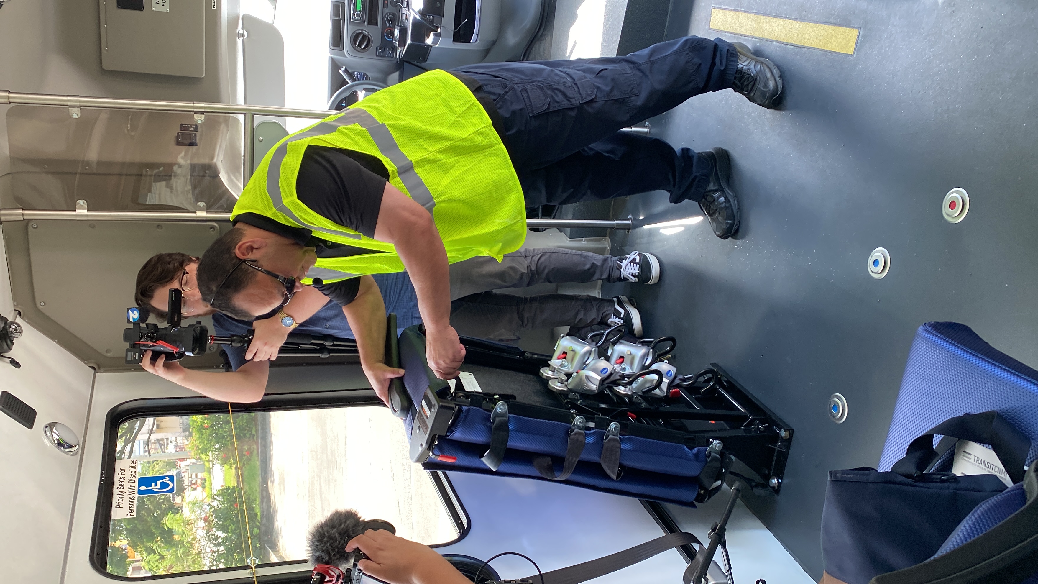 Ernie Bell, the bus driver, folds a pair of bus seats to demonstrate how he would accommodate a  passenger with disabilities.