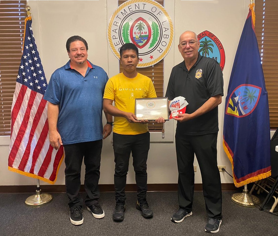 Joel Manalo Lugue of the Philippines, center, is the 5,000th H-2B worker to be registered on Guam. Also in photo are Guam Labor Director David Dell’Isola, right, and Greg Massey, left, GDOL alien labor processing & certification, division administrator.