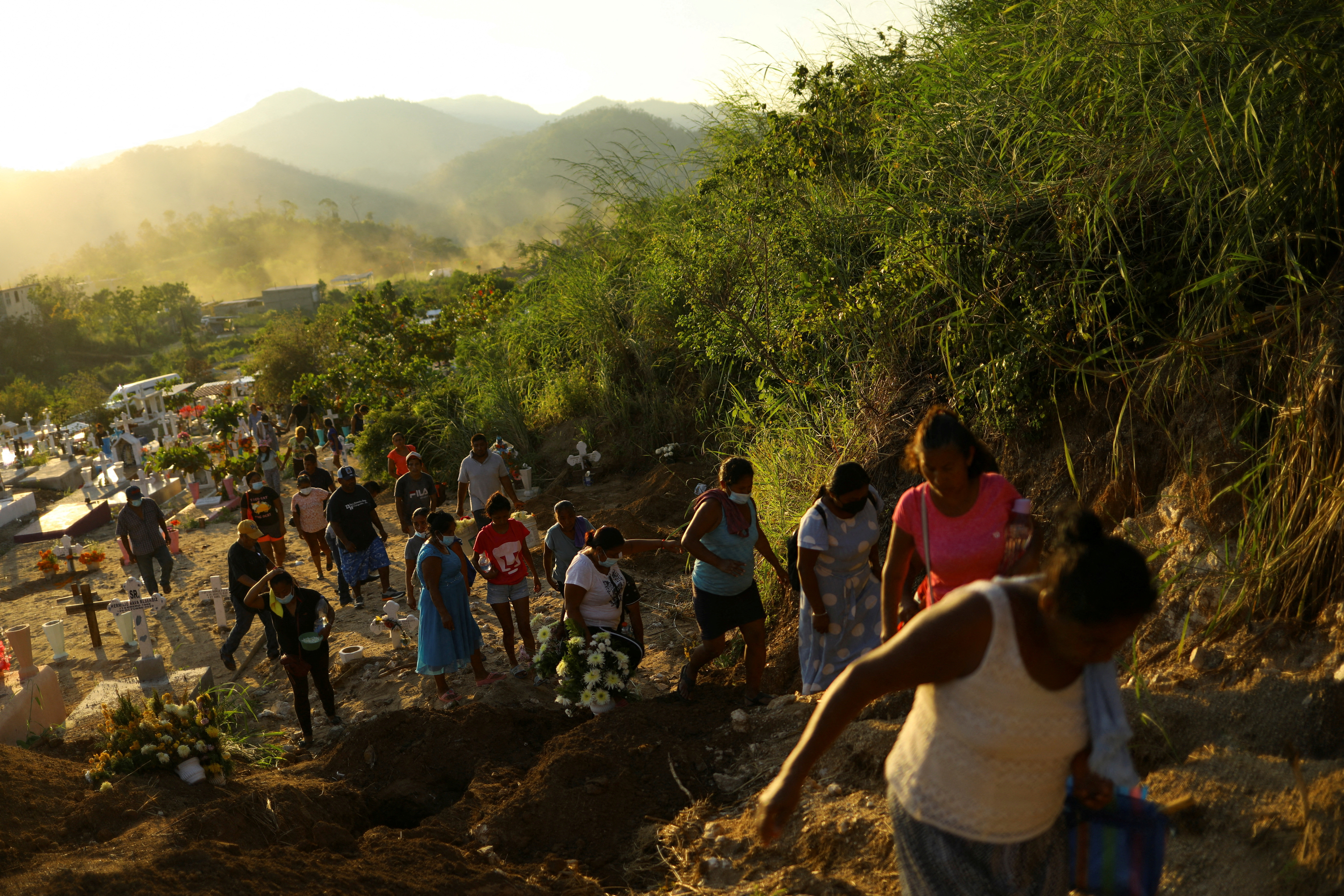 Relatives of late Jose Ramiro Castro Garcia, who died during Hurricane Otis while working aboard a ship, walk through El Palmar cemetery, in Acapulco, Mexico, November 3, 2023. 