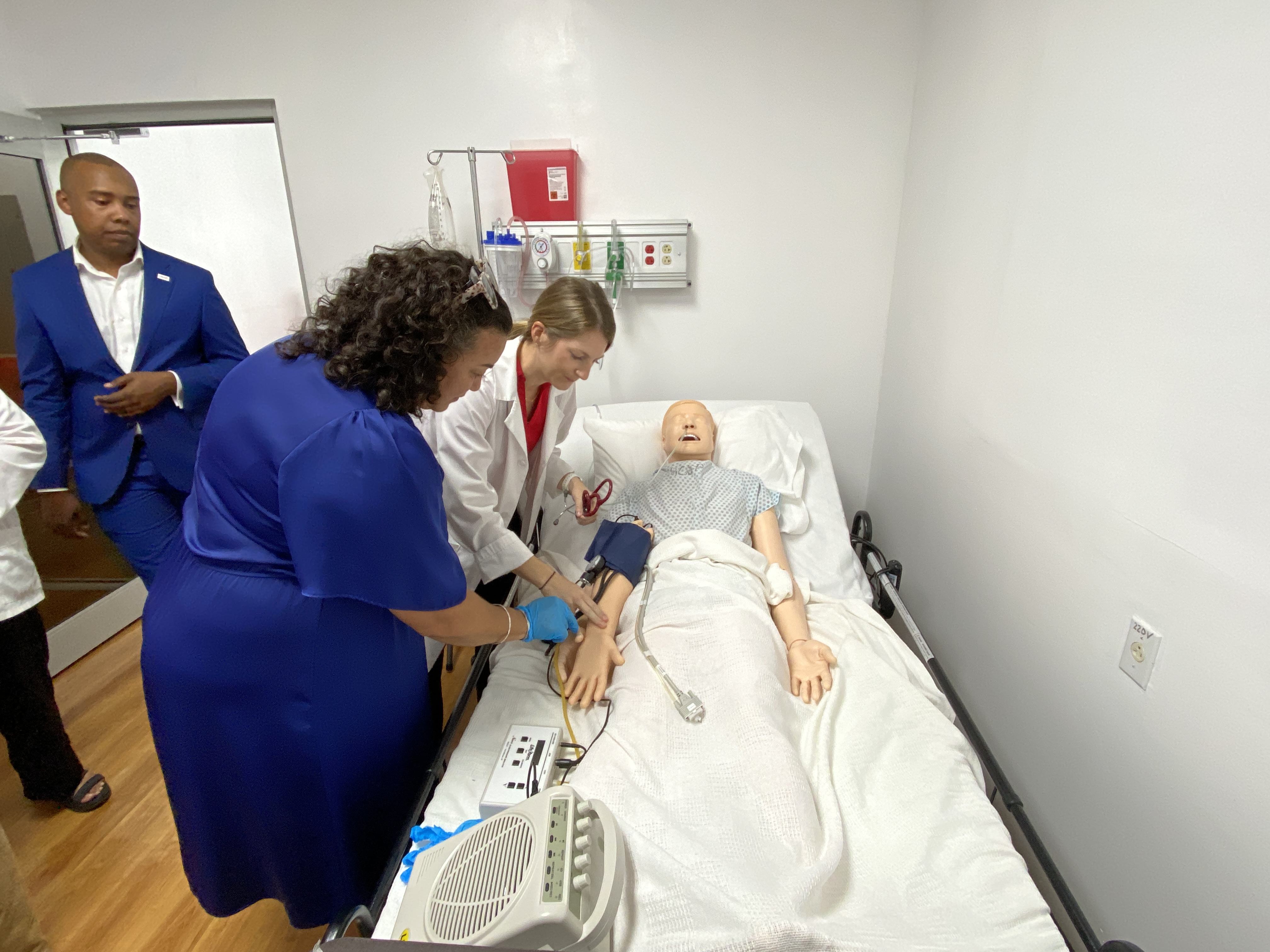 Department of Labor Secretary Leila Staffler checks the pulse of a high-fidelity mannequin at the NMC Health Simulation Center.