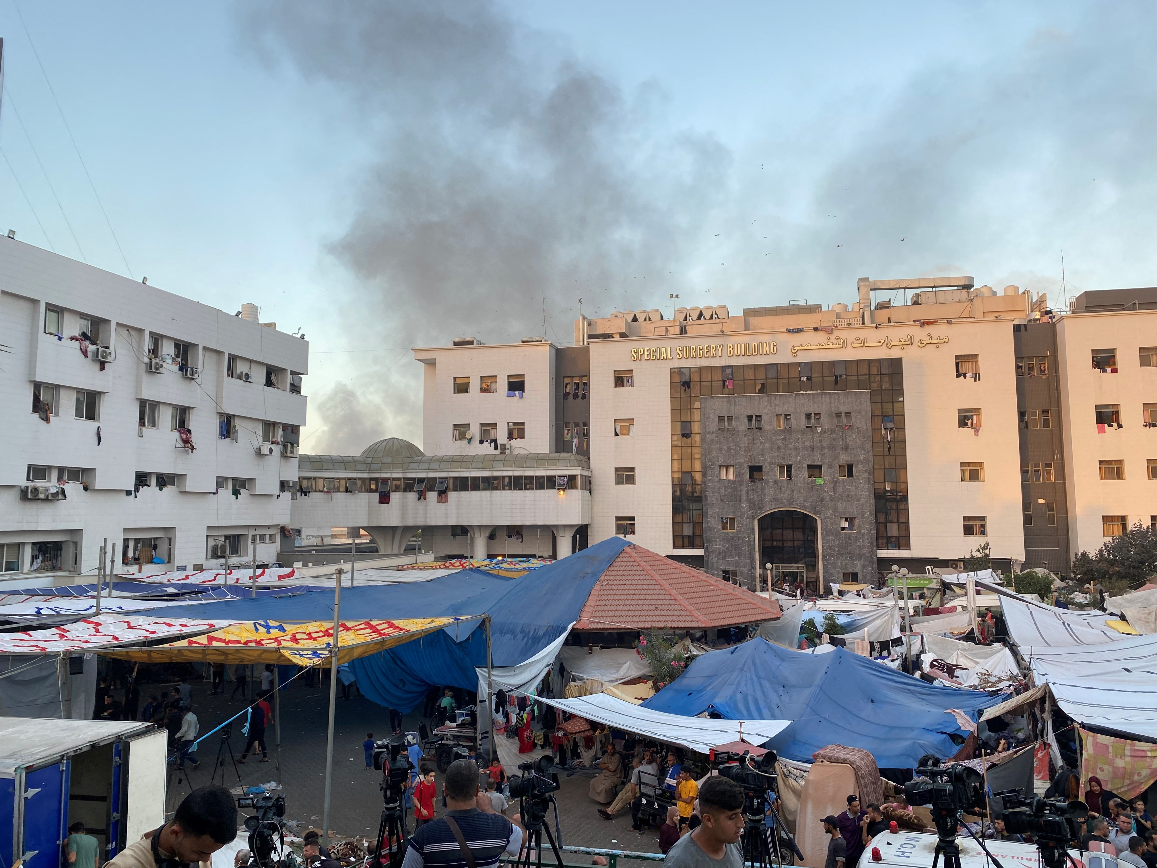 Smoke rises as displaced Palestinians take shelter at Al Shifa hospital, amid the ongoing conflict between Hamas and Israel, in Gaza City, November 8, 2023. 