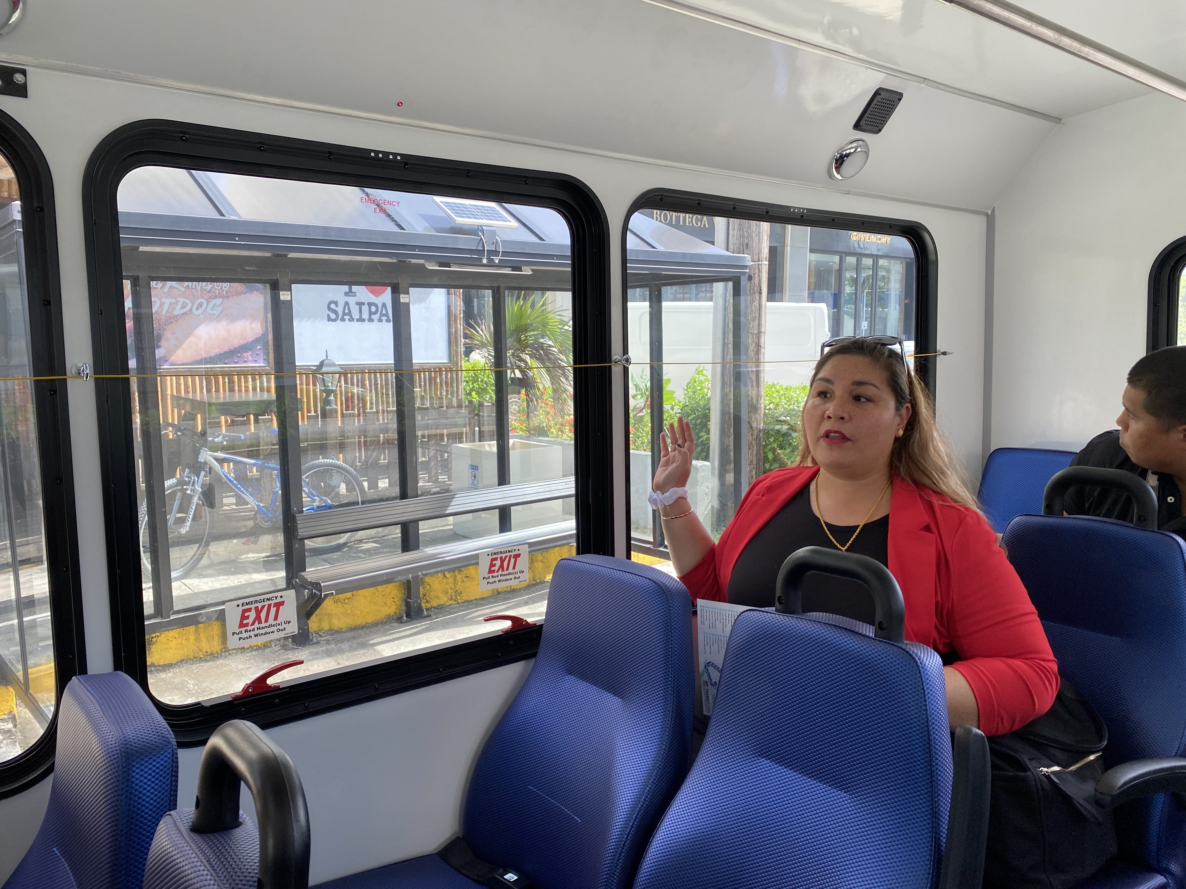 Special Assistant for Transportation Alfreda Camacho Maratita gestures as the bus stops at a bus shelter at I Love Saipan. 