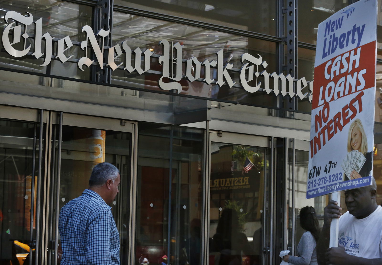 People walk past the New York Times Building in New York August 14, 2013. People accessing nytimes.com earlier on Wednesday saw a message that the service was unavailable. New York Times Co spokeswoman Eileen Murphy said the company thinks the cause of the outage was related to a scheduled maintenance update, which occurred within seconds of the website going down. 